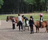 Amanda Haglund hjälper eleverna upp på de snälla hästarna.