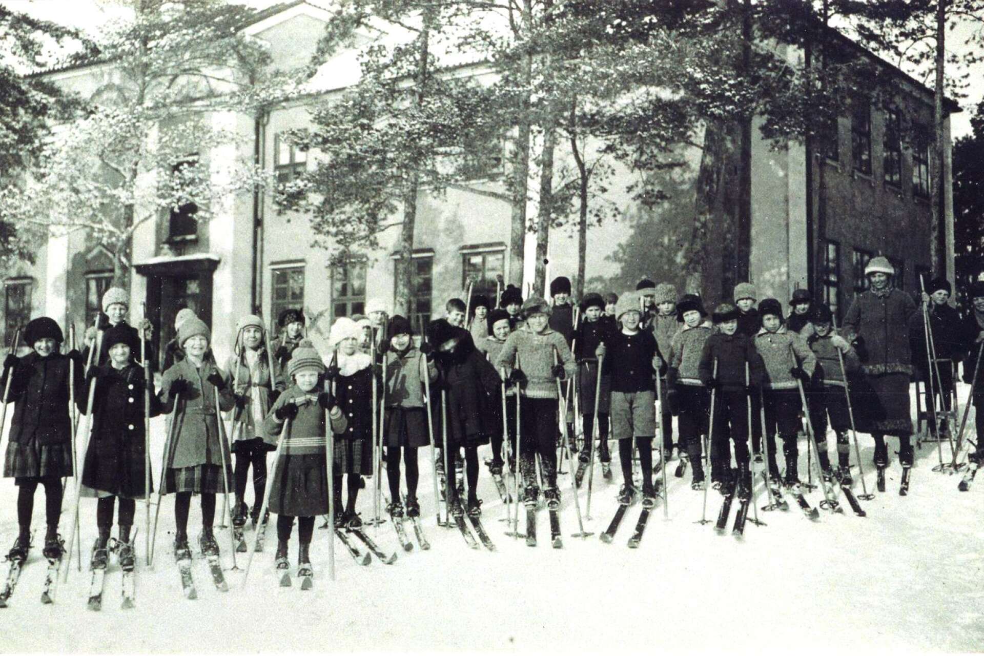 Skidåkande skolbarn vid brukets skola i Skoghall på 1930-talet. Det är samma byggnad som Hammarö auktionsverk i dag har sin verksamhet i. 