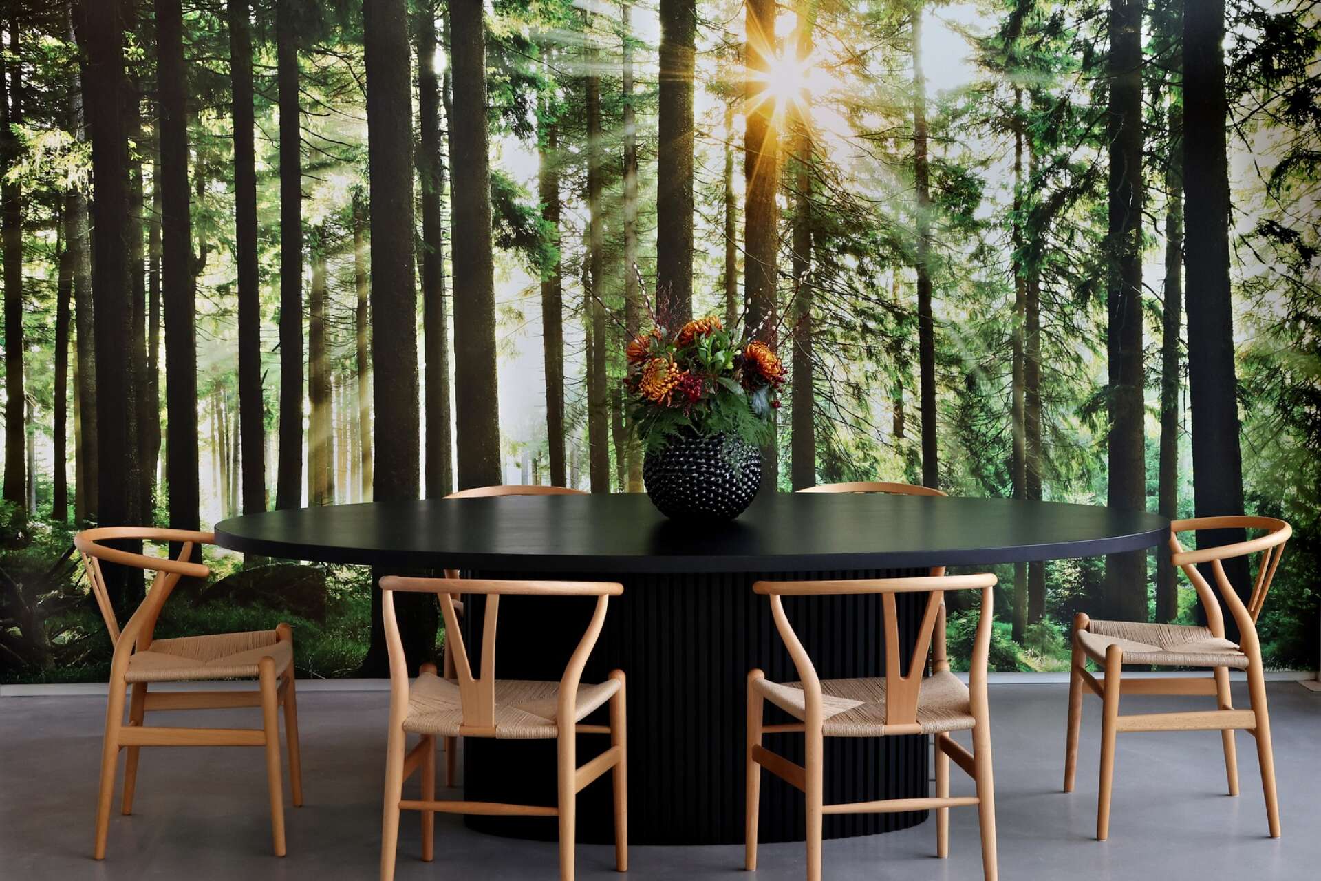 Måltiderna intas ”i skogen” på stolar formgivna av Hans J. Wegner.