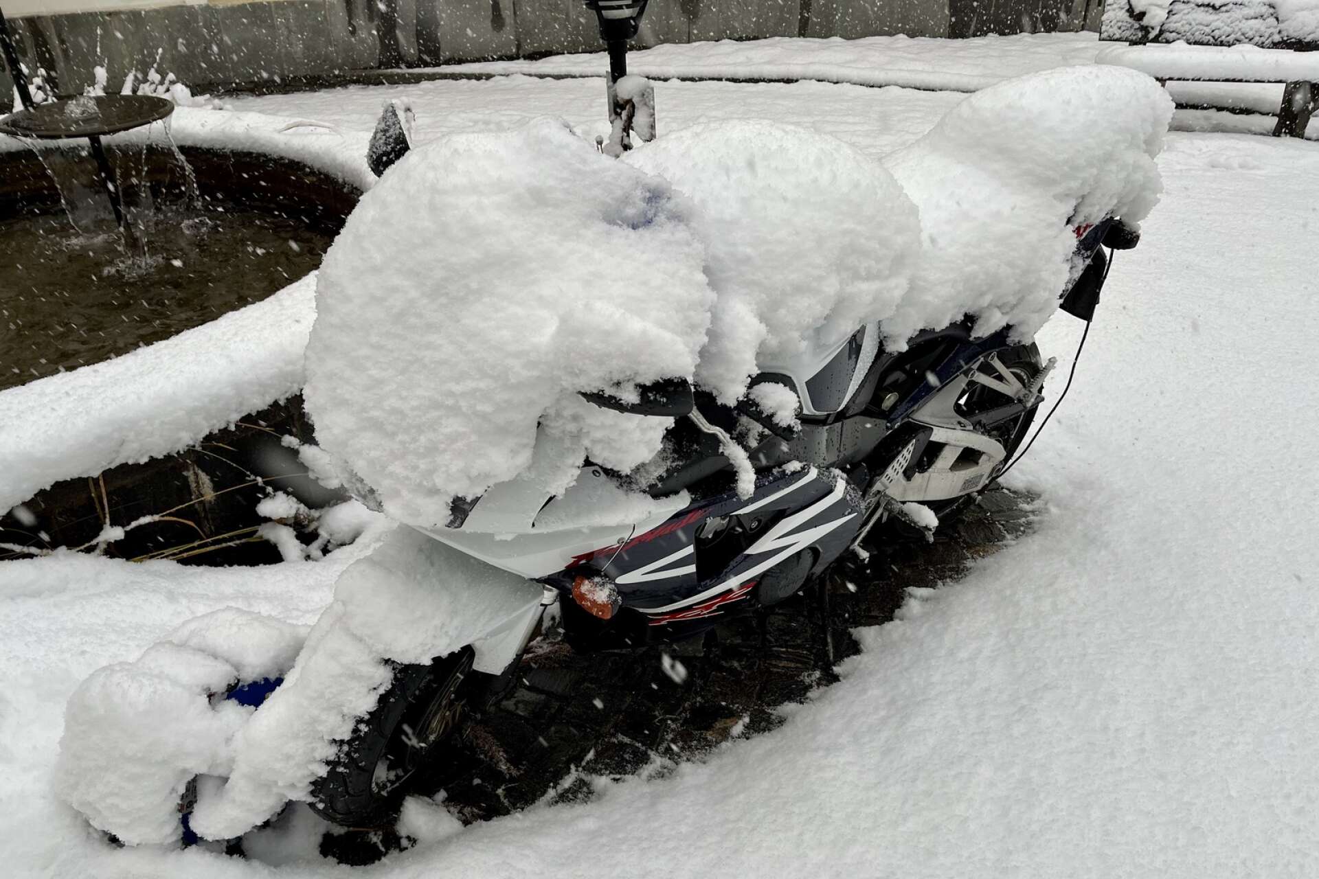 Det finns en motorcykel under snön. 