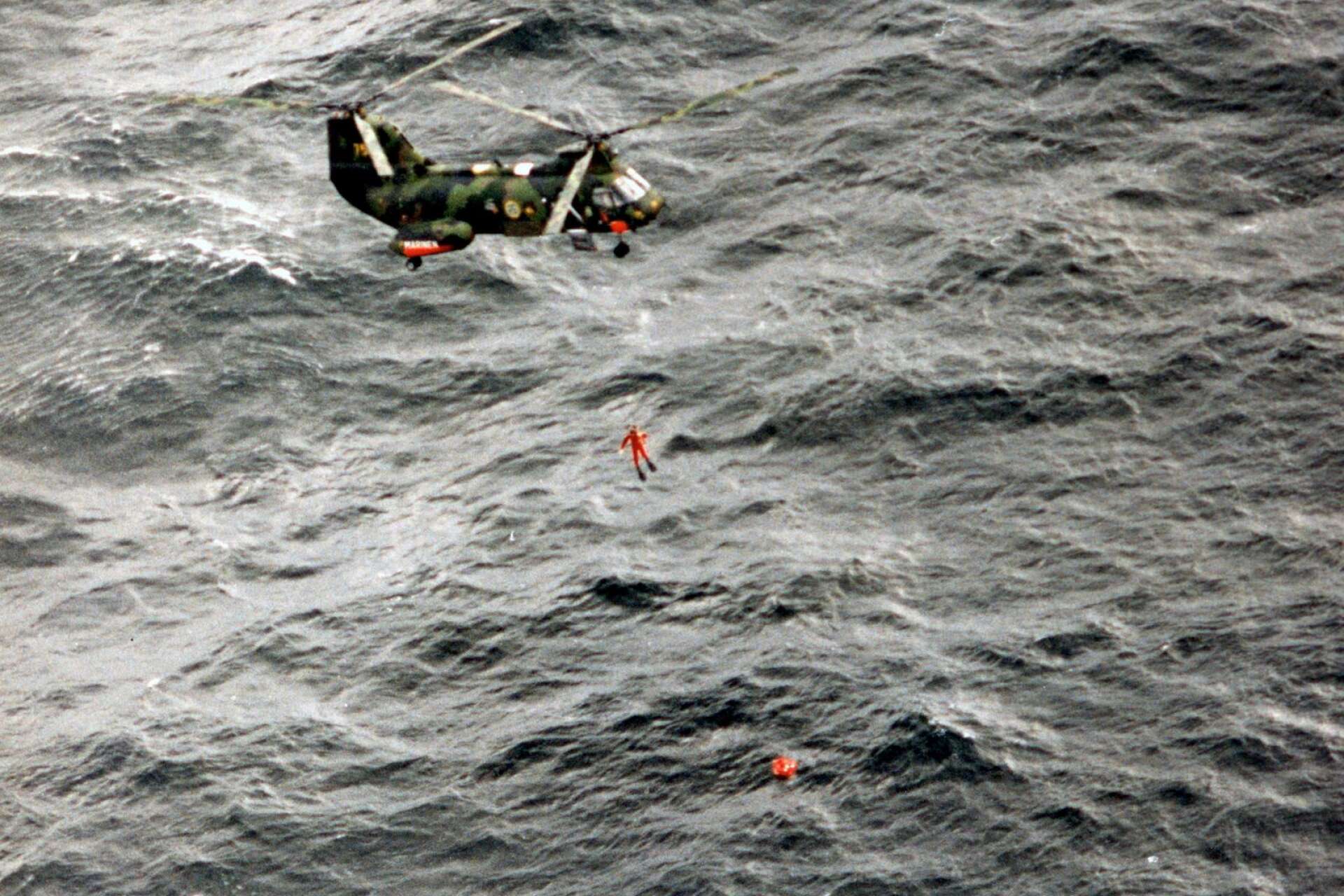 28 september 19940. En ytbärgare från en svensk helikopter på väg ner mot en livräddningsflotte. ”De riskerade sin egen hälsa och liv”, säger Anders Eriksson om ytbärgarnas insats.