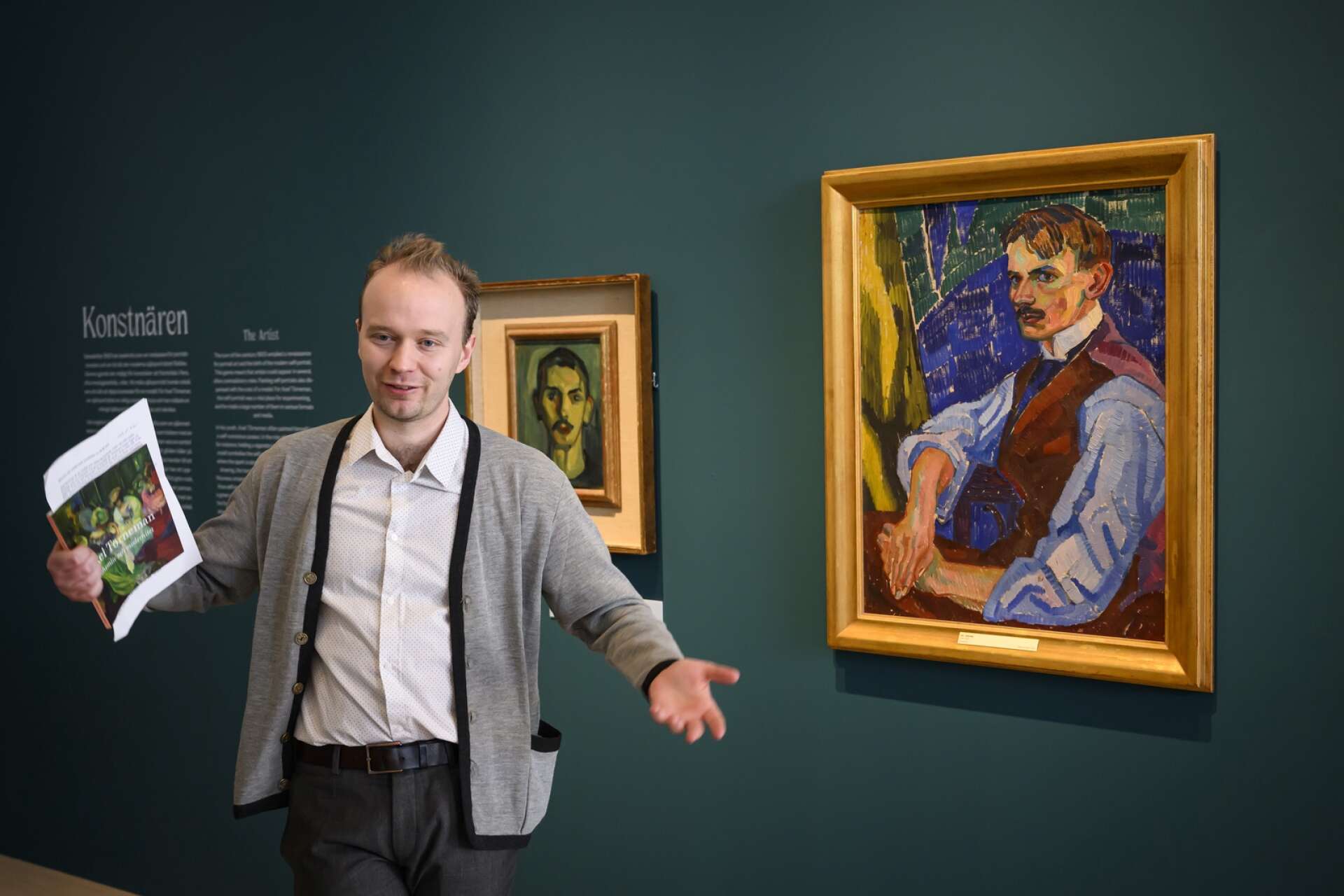 Adam Korpskog visar ett av Axel Törnemans självporträtt. Flera sådana, från olika tider i konstnärens korta liv, finns på utställningen.