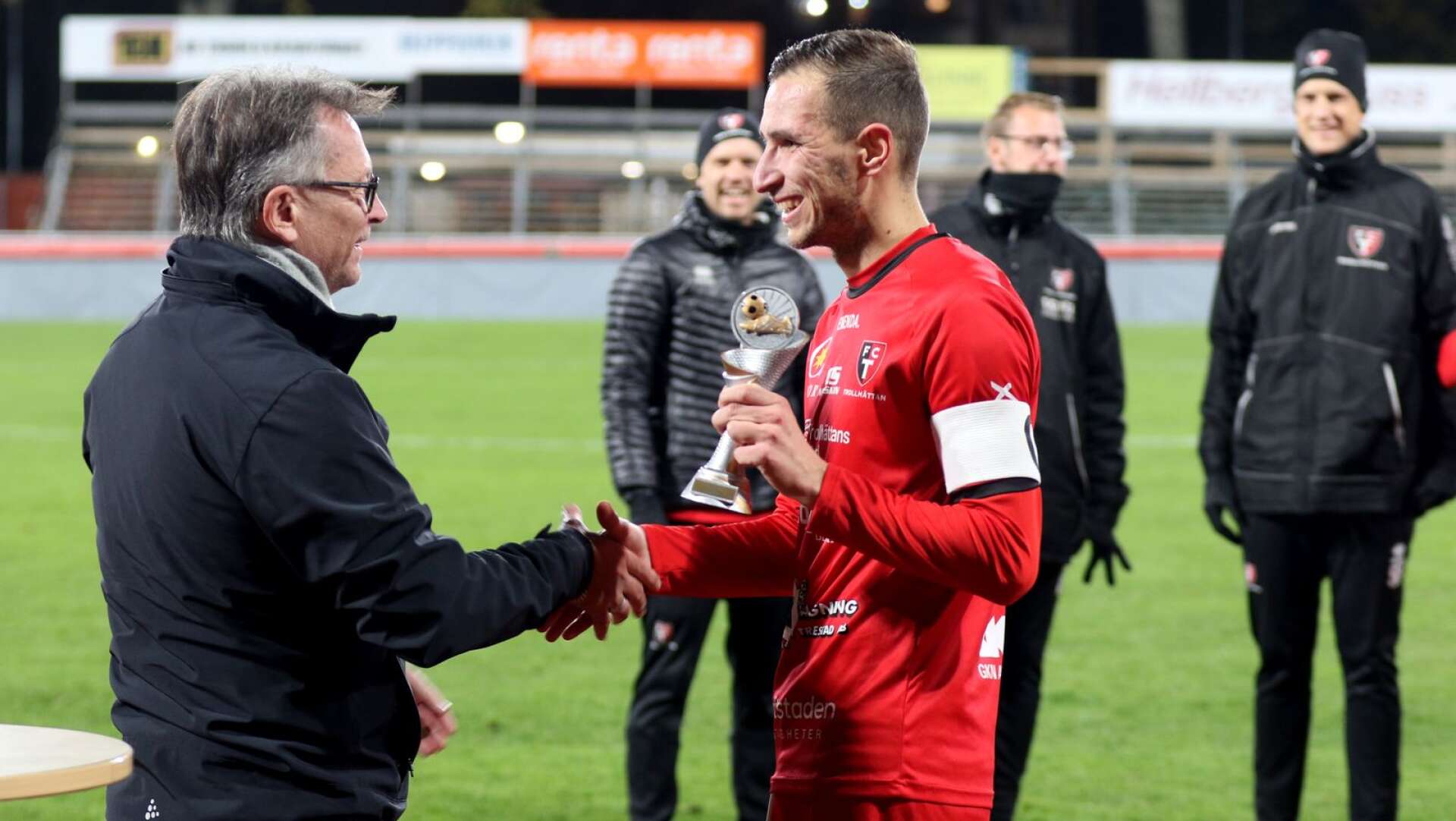 Alen Kasumovic i FC Trollhättan tar emot pokalen ifrån Peter Karlsson ifrån Västergötlands Fotbollförbund.