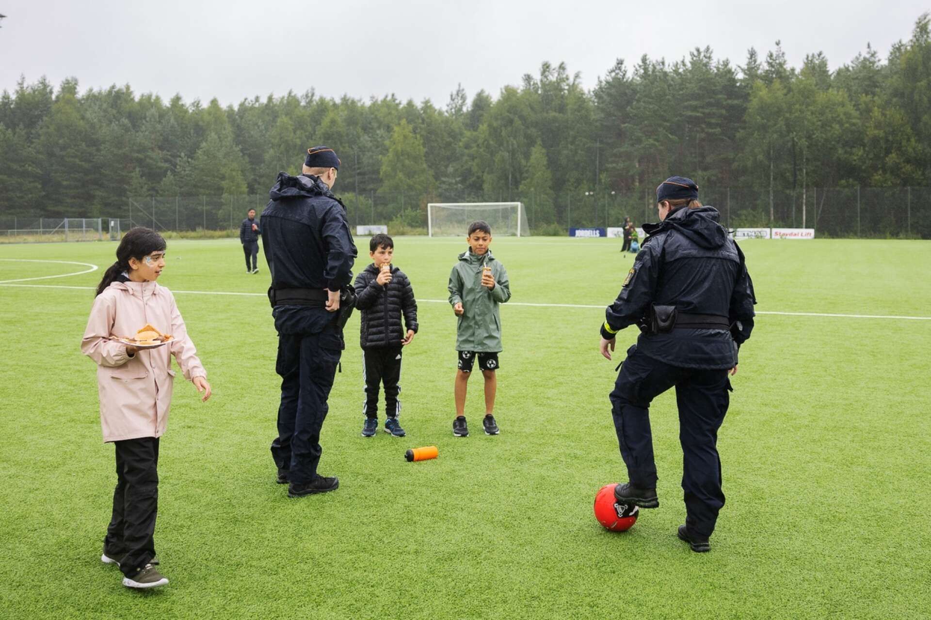 Poliserna Klara och Johan spelar boll med några besökare.
