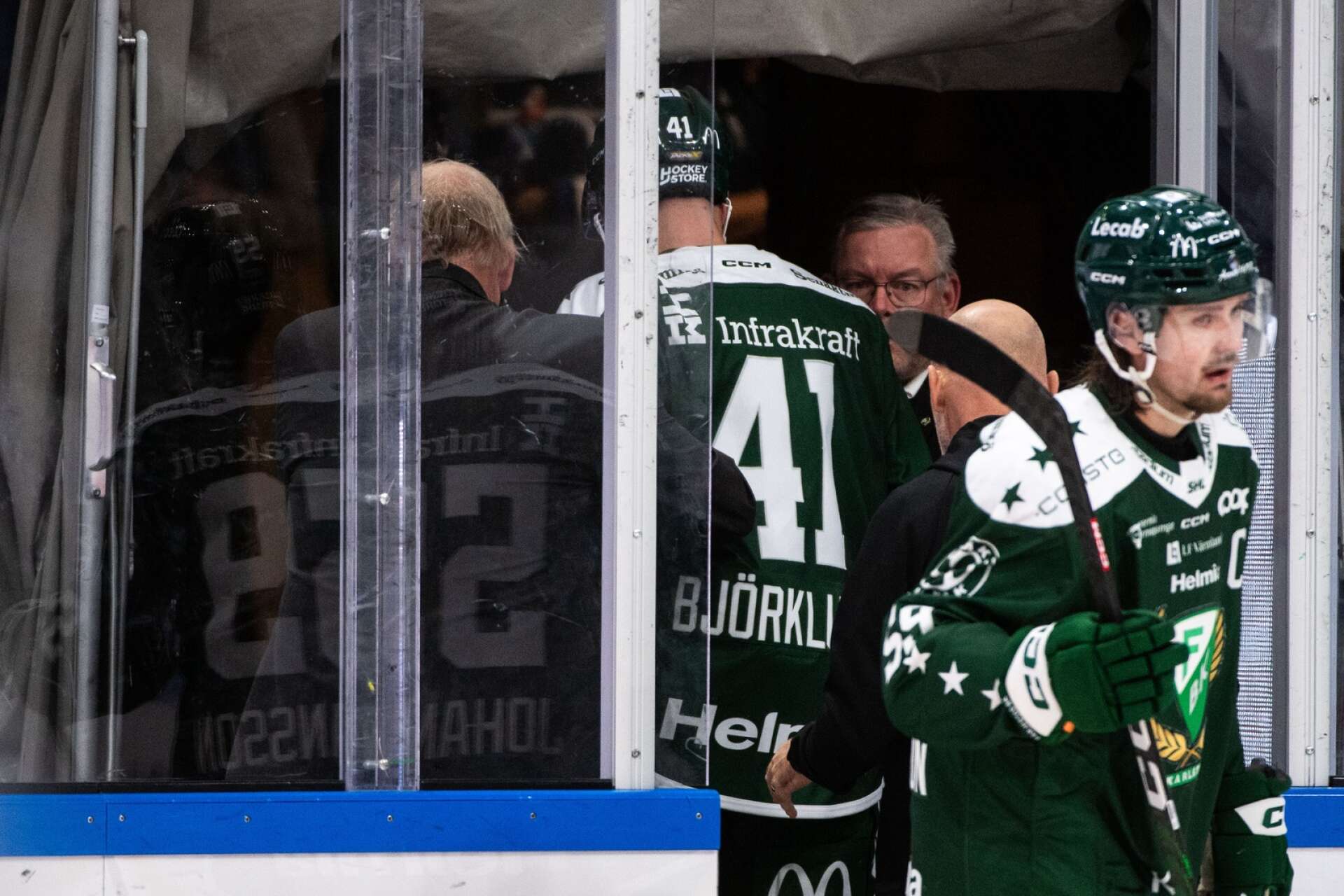 Henrik Björklund lämnar isen efter att ha fått Anton Lindholms axel i huvudet.