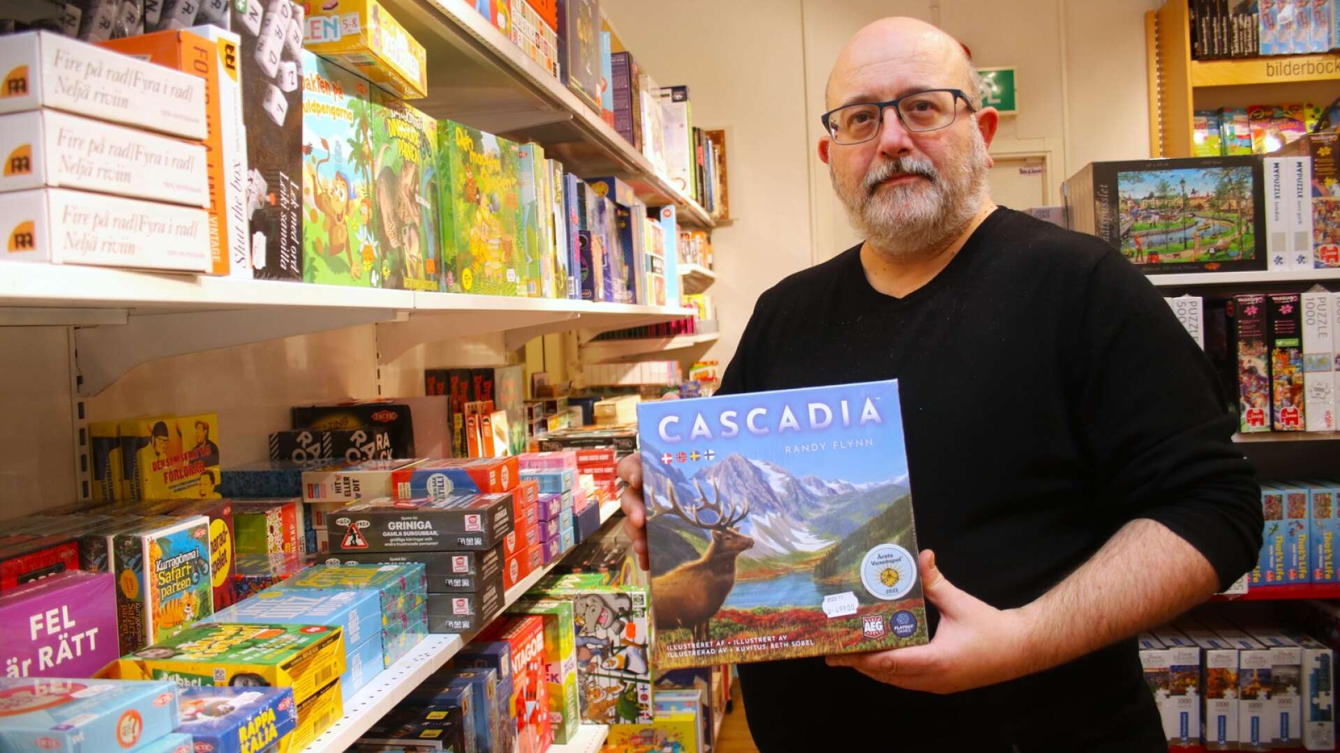 Sällskapsspelet har utsetts till årets julklapp. Något som glädjer Jürgen Picha på Åmåls bokhandel. I handen håller han spelet Cascadia som i år erhöll ”Guldtärningen” för årets bästa sällskapsspel i kategorin vuxenspel.