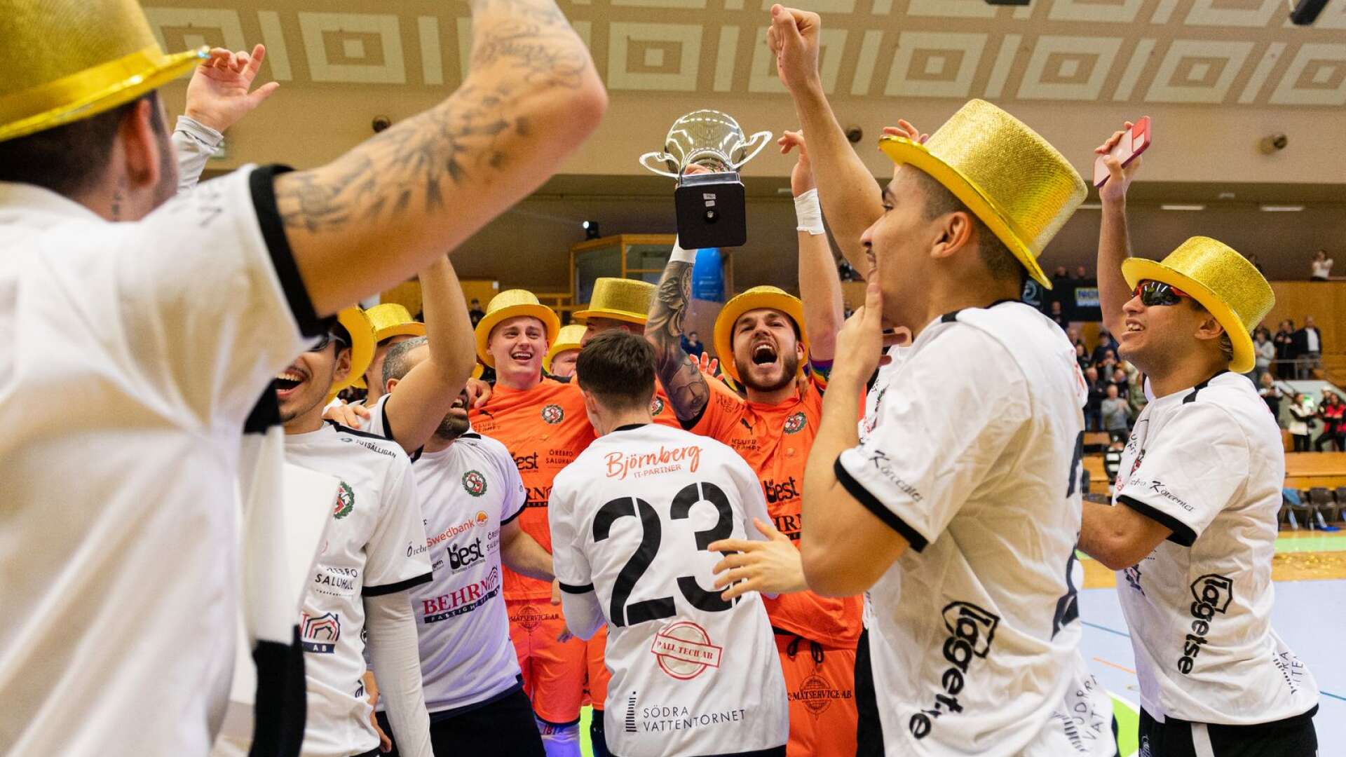 Martin Herlin (i orange till höger) fick höja SM-bucklan efter att hans Örebro SK vunnit finalen mot IFK Uddevalla i den svenska futsalligan.