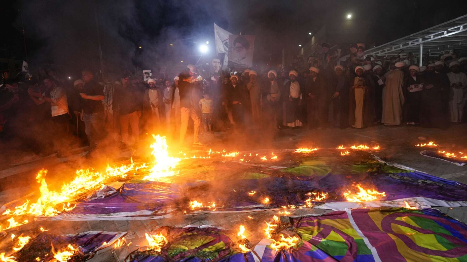 Regnbågsflaggor bränns vid en demonstration i Baghdad.