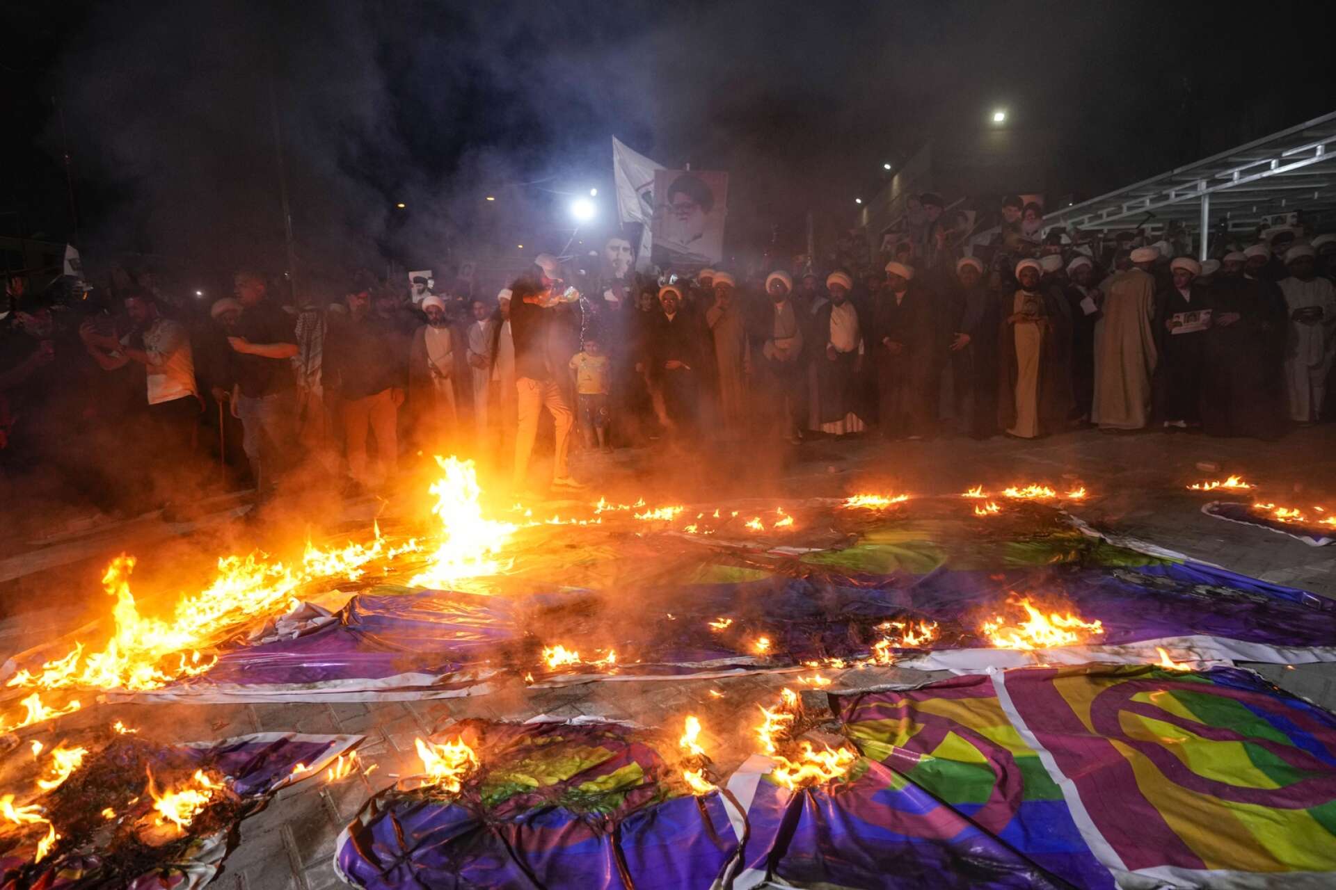 Regnbågsflaggor bränns vid en demonstration i Baghdad.