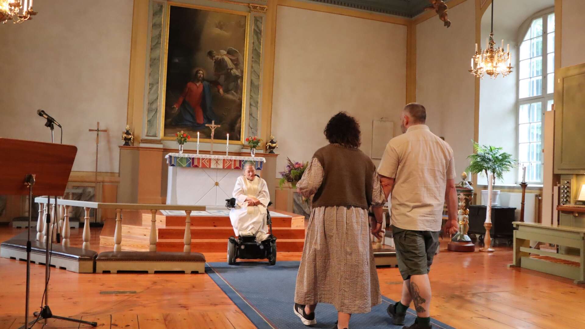 Camilla Klint och Daniel Johansson går fram till prästen Maria Norberg för vigsel i Hova kyrka. 