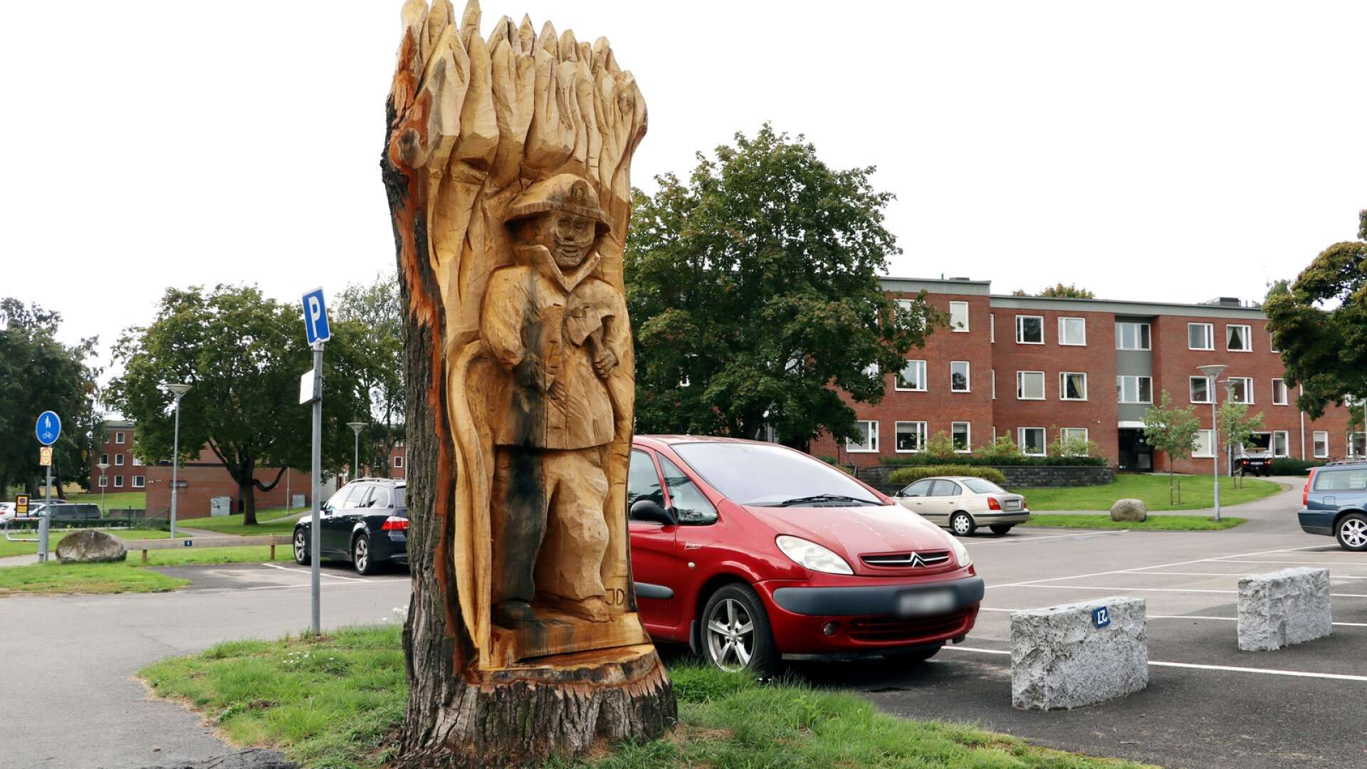 Skulpturen Brandmannen ståtar på parkeringsplatsen i bostadskvarteret mellan Skövdevägen och Villagatan.