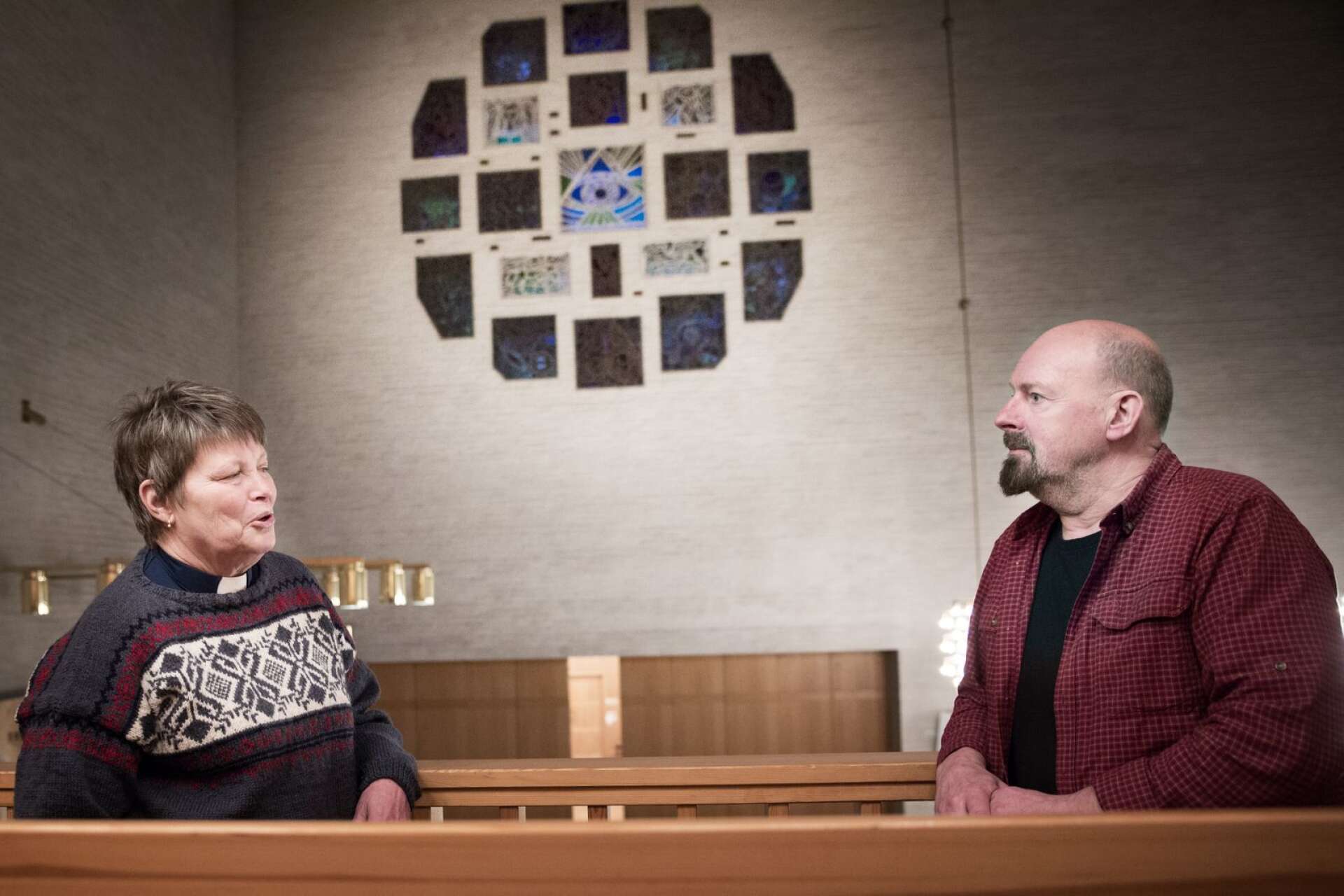 Prästen Lena Skoting och Stefan Ferger från Ljudmakaren diskuterar ljusspelet som ska visas på Säffle kyrkas fasad under julhelgen. Fönstret i bakgrunden ska också lysas upp, inifrån, så att det syns från utsidan.