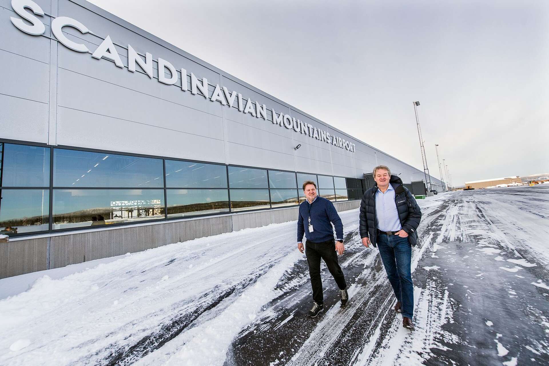 Byggledaren Trond Moen och Sysslebäcksbon Bosse Halvardsson från flygplatsstyrelsen utanför den terminal som möter de skidturister som från och med söndag väljer att ta flyget till snön.