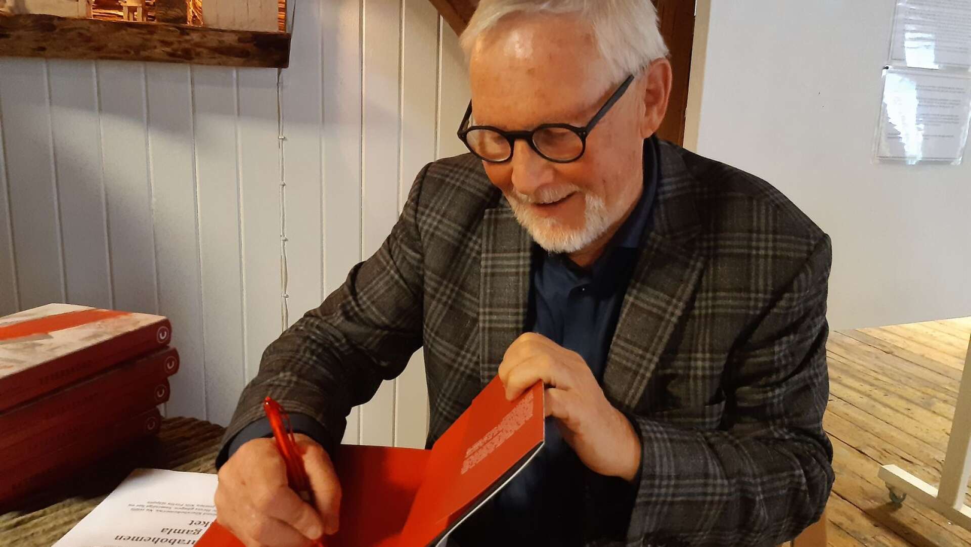 Hans Rutberg är ordförande i Nils Ferlinsällskapet och tillika systerdotterson till Ferlin. Rutberg gav ifjol ut boken ”Efterskörd-Ferlinfynd från en spånkoffert”, här signerar han boken under sitt besök på Museet Kvarnen.