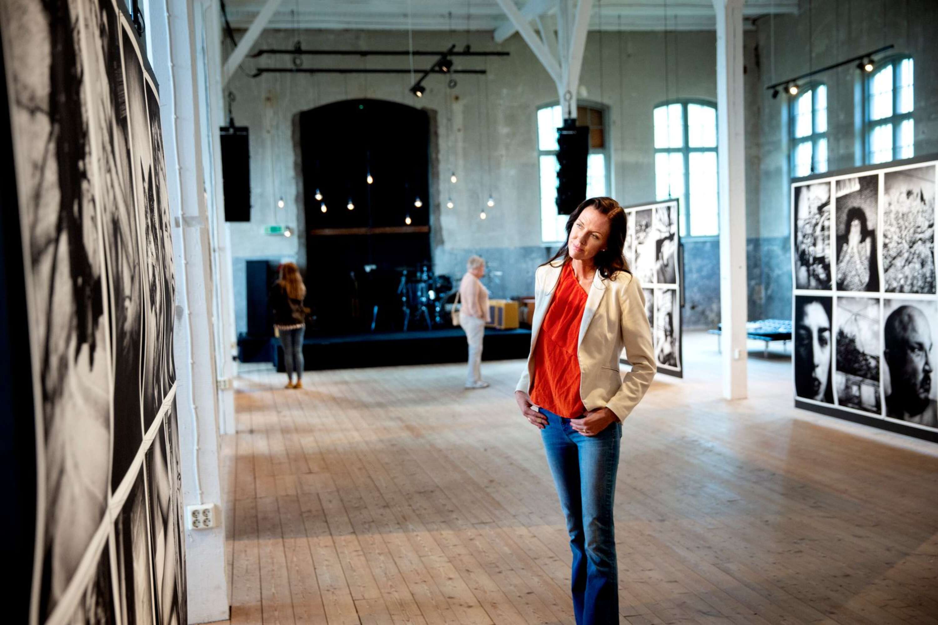 Johanna Magnusson roddar i konsthallen. Framför henne hänger verk av fotografen Anders Petersen.