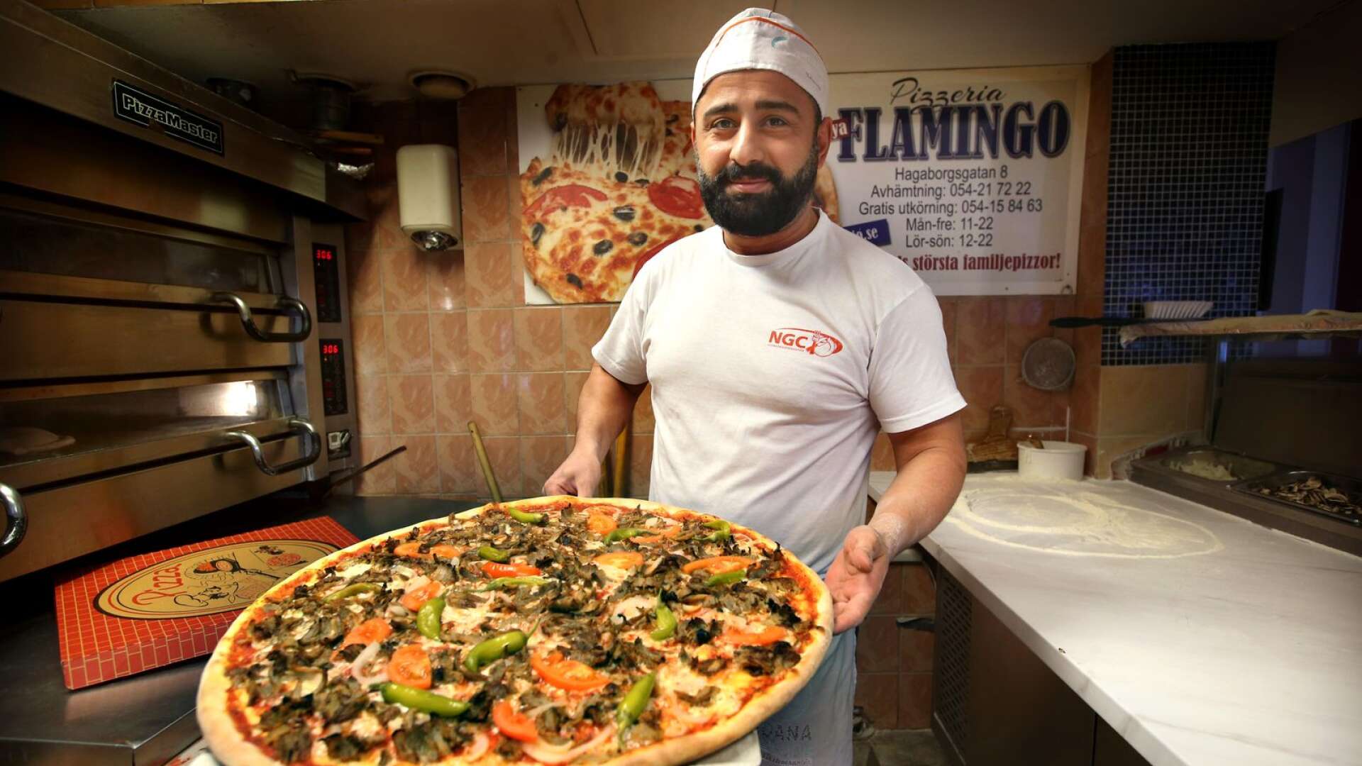 Pizzabagaren Karwan Ismail visar upp en favorit hos Nya Flamingos kunder, en kebabpizza av familjestorlek.