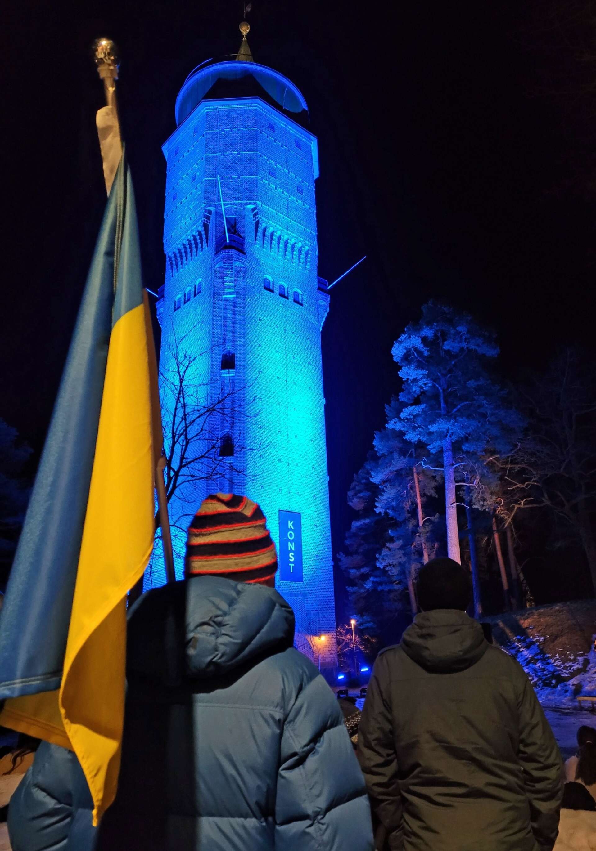 Den ukrainska fanan framför vattentornet som var belyst i Ukrainas blåa och gula färger 