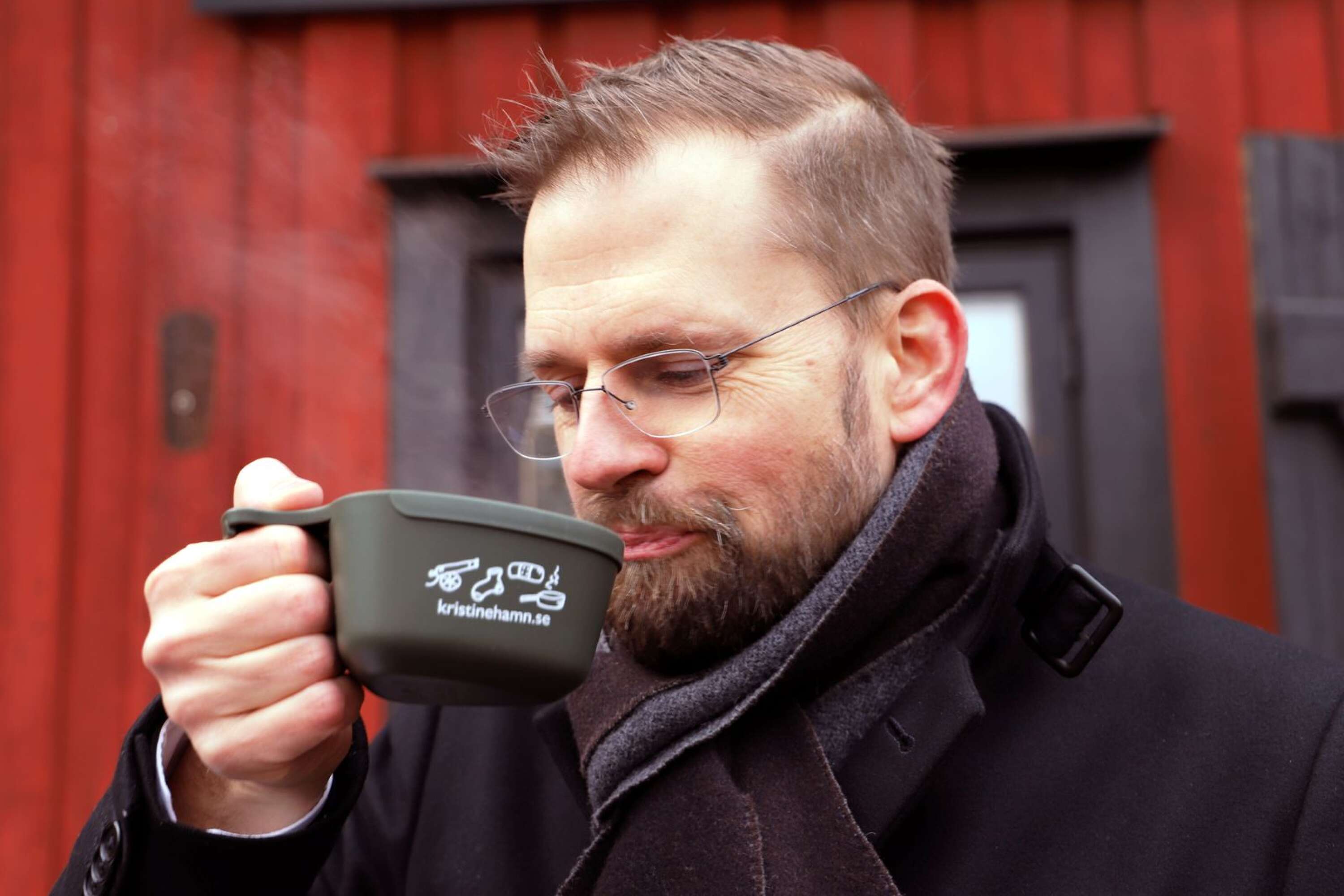 Kaffe bjöds ur fältmässiga kåsor. Kommundirektören Martin Willén värmde sig.