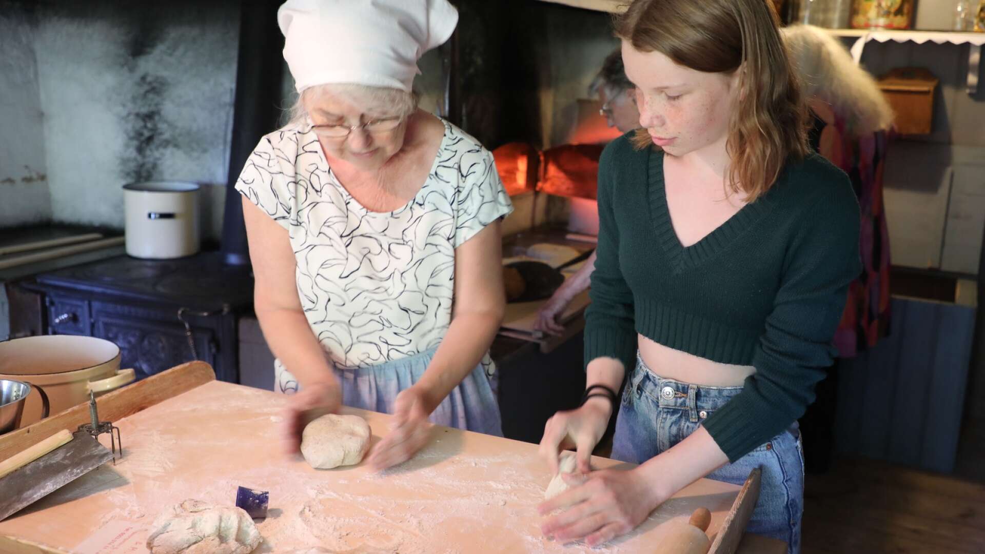 Hembygdsdag med gamla hantverk,  Monica fick hjälp av Malva med kavlingen av brödkakorna.