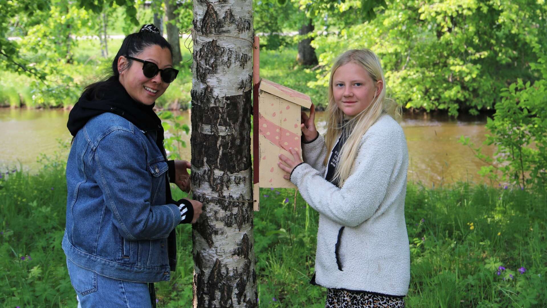 Läraren Teresa Sheh och eleven Astrid Karppenen hjälps åt med att sätta upp en fågelholk.