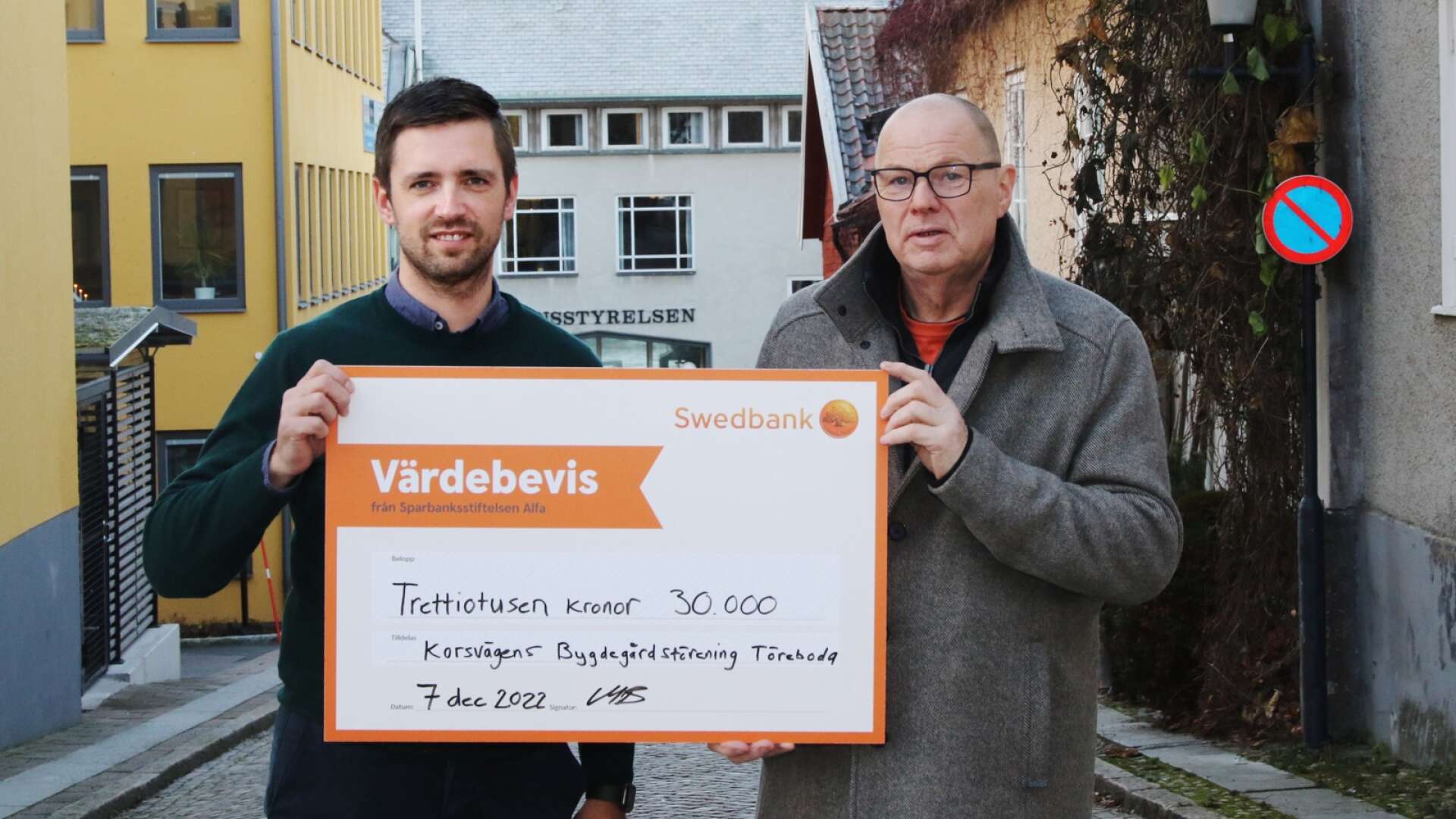 Swedbanks Martin Blanck lämnar över ett värdebevis från Alfastiftelsen till Korsvägens bygdegårdsförening. Styrelsemedlemmen Anders Johansson tar emot. 