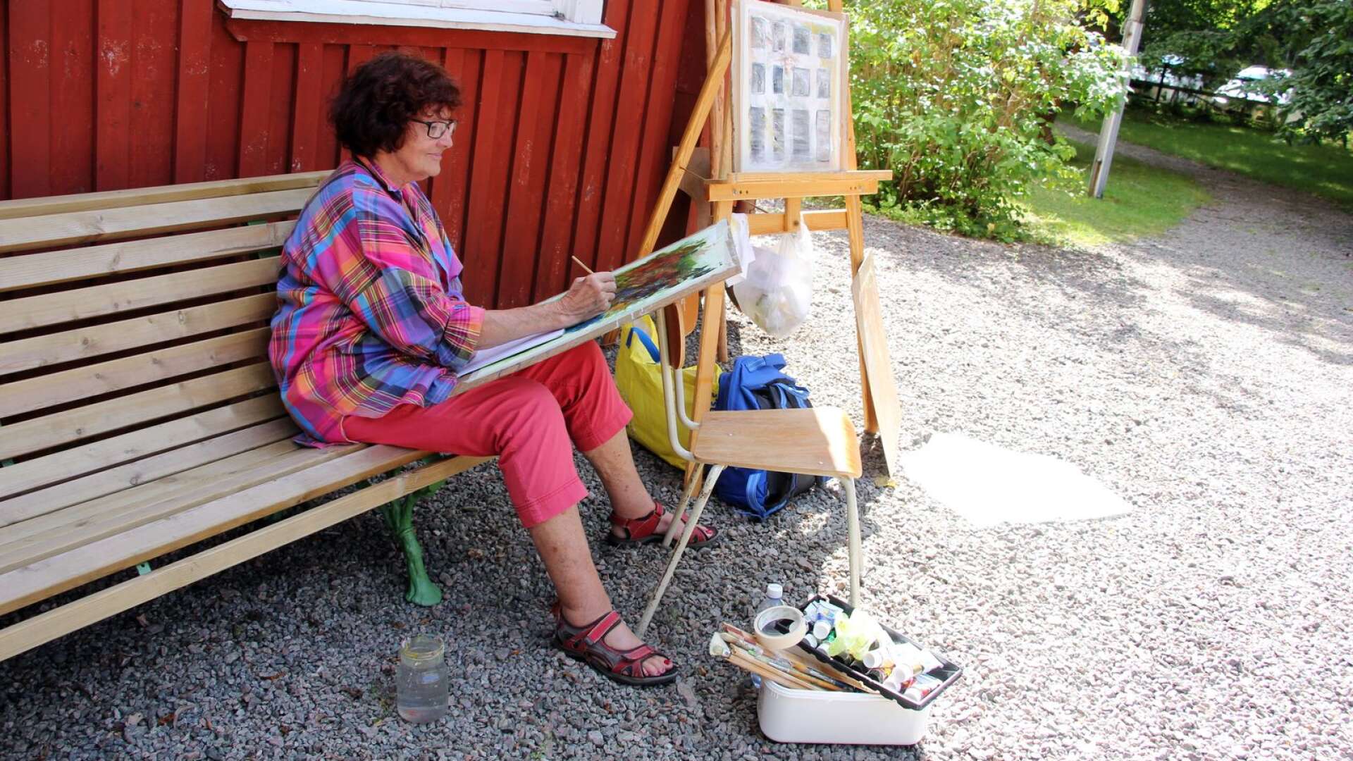 Lisbeth Gustavsson sitter och målar utanför Alltorps Tingshus.