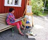 Lisbeth Gustavsson sitter och målar utanför Alltorps Tingshus.