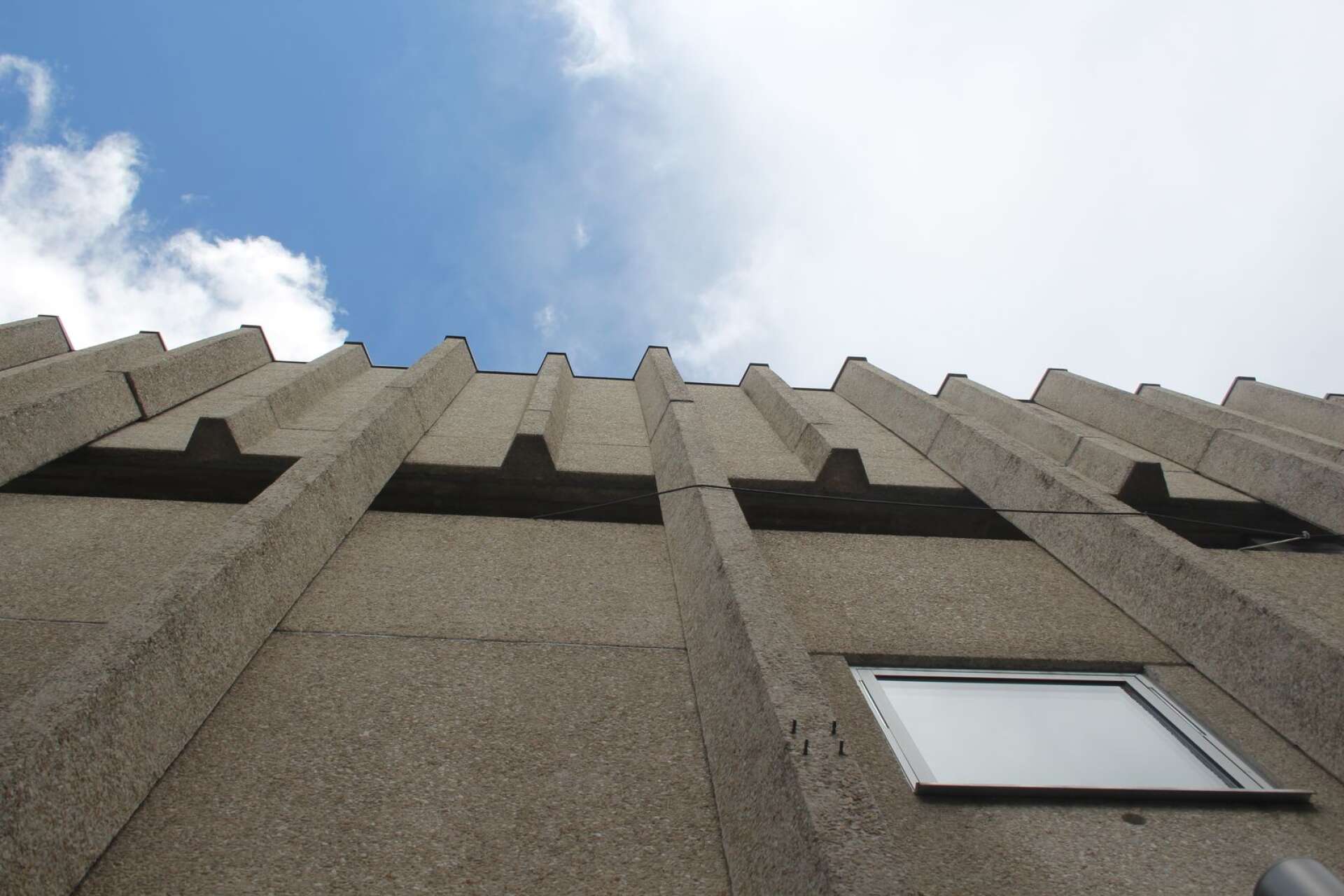 Brutalisthuset, fd Epa-huset i Arvika, reser en taggig betongfasad mot himlen.
