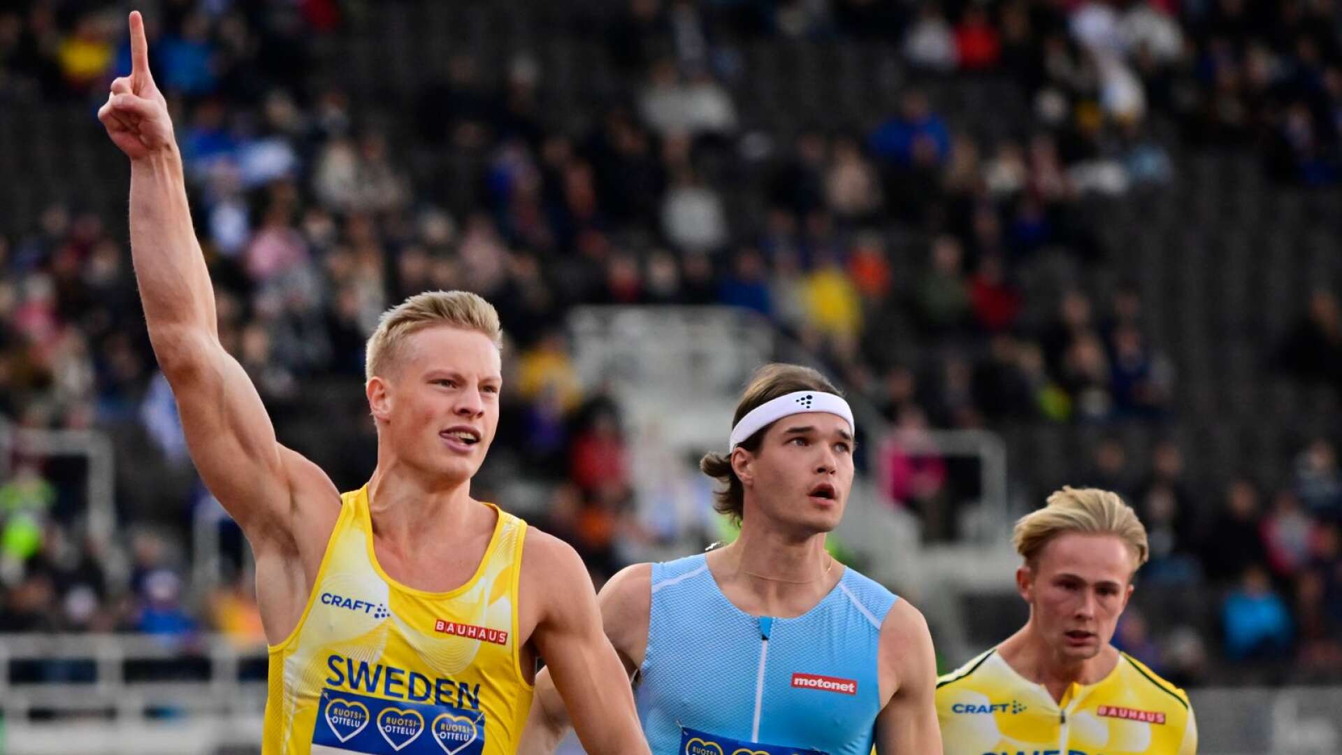 Sveriges värmlänning Henrik Larsson firar segern på 100 meter på Finnkampen. Till höger Finlands Santeri Örn och Sveriges Viktor Thor.