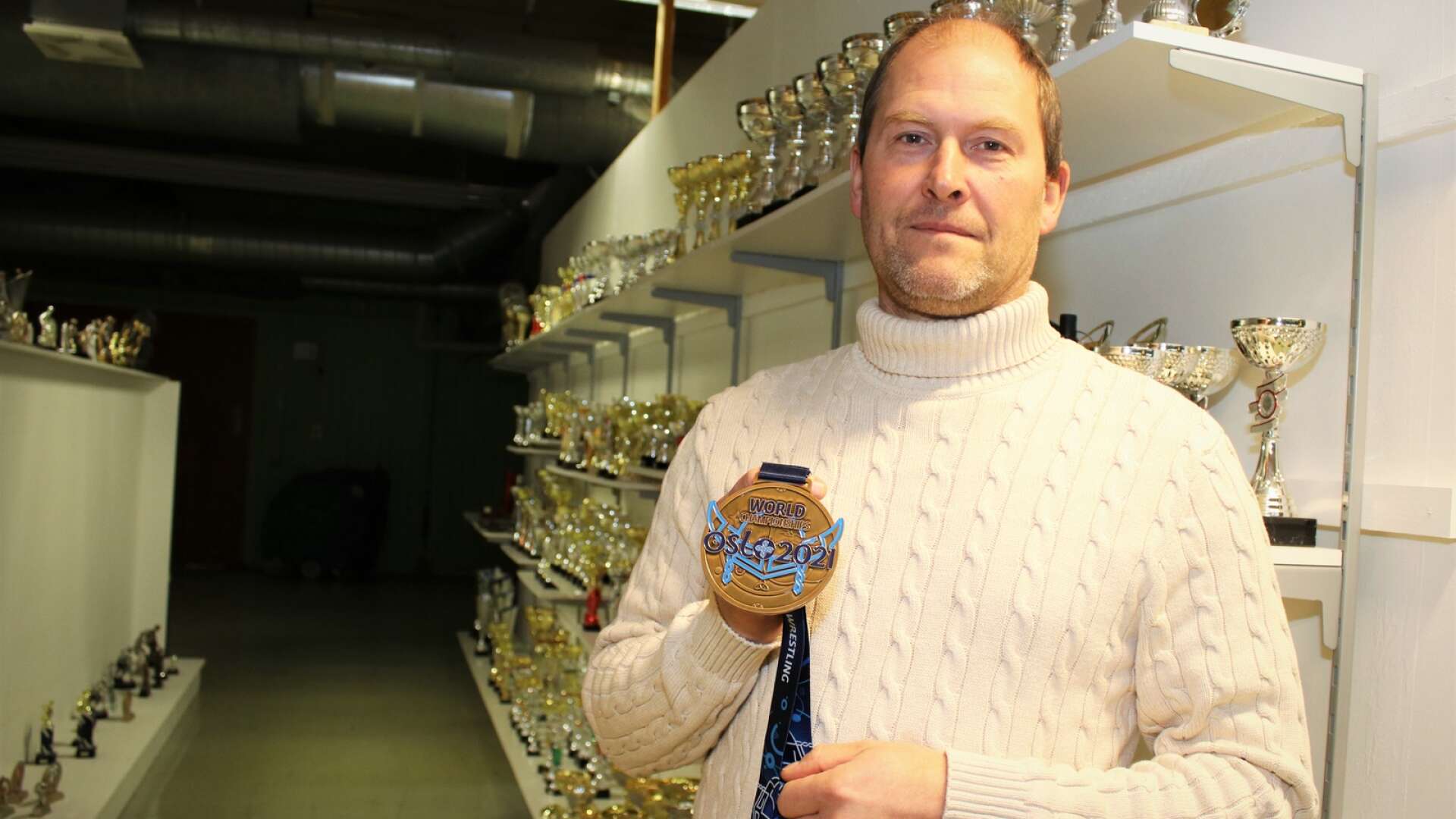 Anders Pettersson visar upp medaljen som företaget tog fram och designade till brottnings-VM i Oslo.