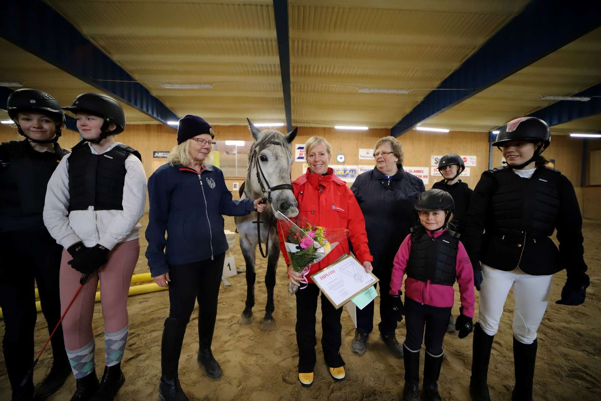 Lena Arwedahl från Länsförsäkringar Älvsborg delade ut priset Lovande förebilder till Bengtsfors ridklubb. Här med Mia Saga, ordförande, Margareta Johansson, stallchef, nyinköpta hästen Silver och en grupp ungdomar.