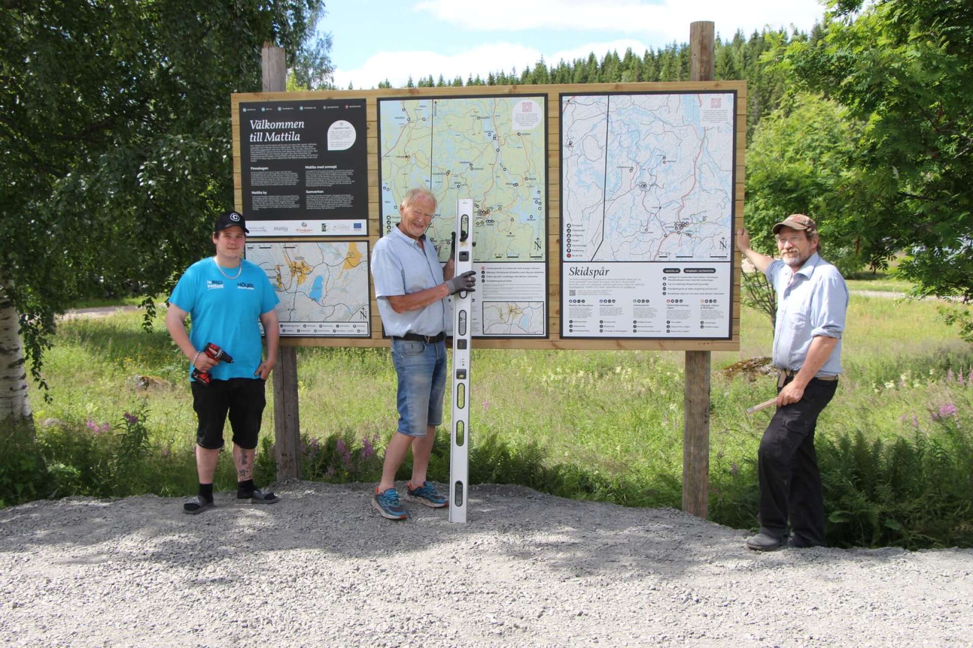 Nya skylten visar vandringsleder i Mattila. Från vänster: Pierre Bäckman, Kurt Eide och Olov ”Skogs-Ola” Henriksson.