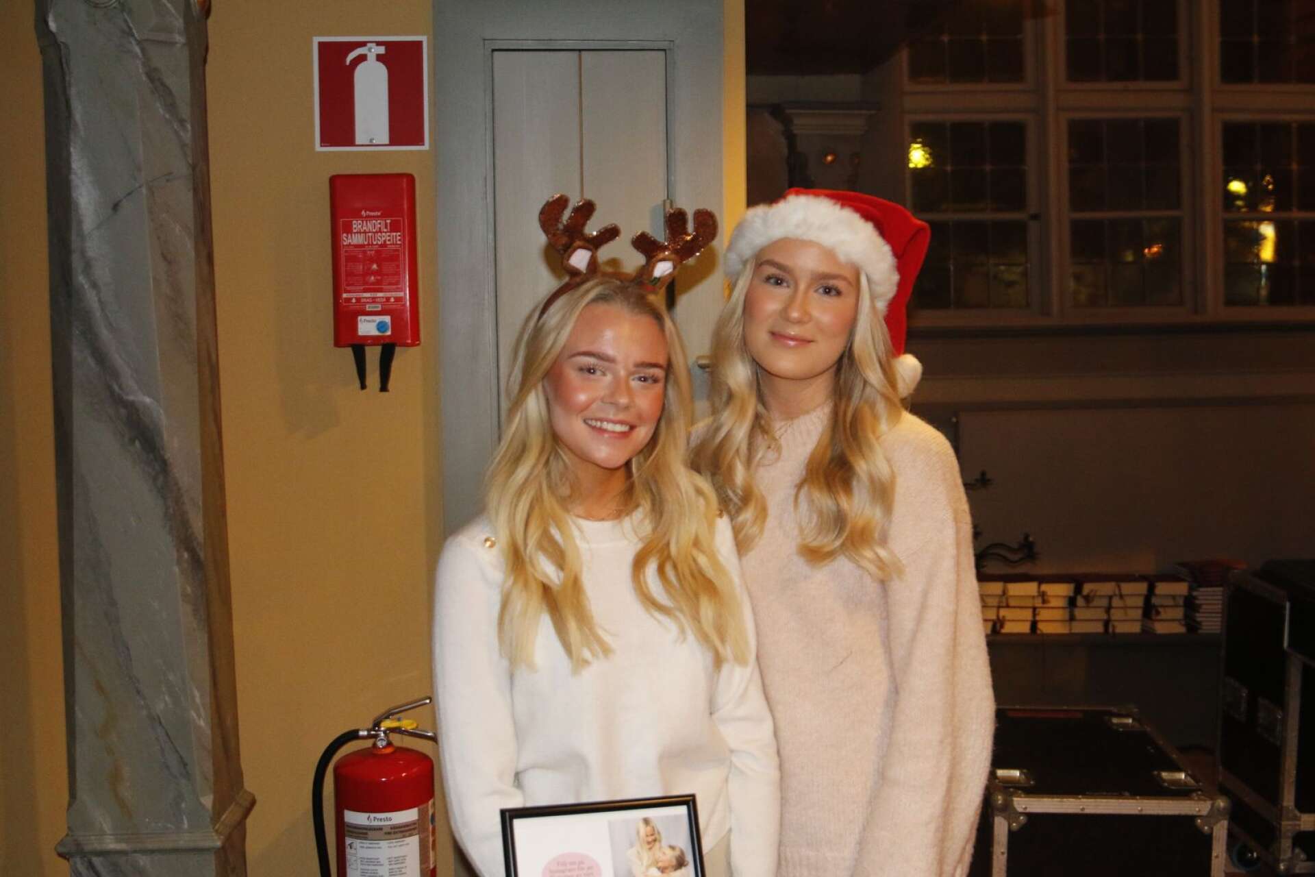Elvira Hallqvist och Nova Zmorzynski stod vid ingången och välkomnade gästerna och sålde genom sitt UF-företag, Amicitia UF, egengjorda julgranskulor, där 50 kronor för varje såld julgranskula går till att köpa julklappar till barn.
