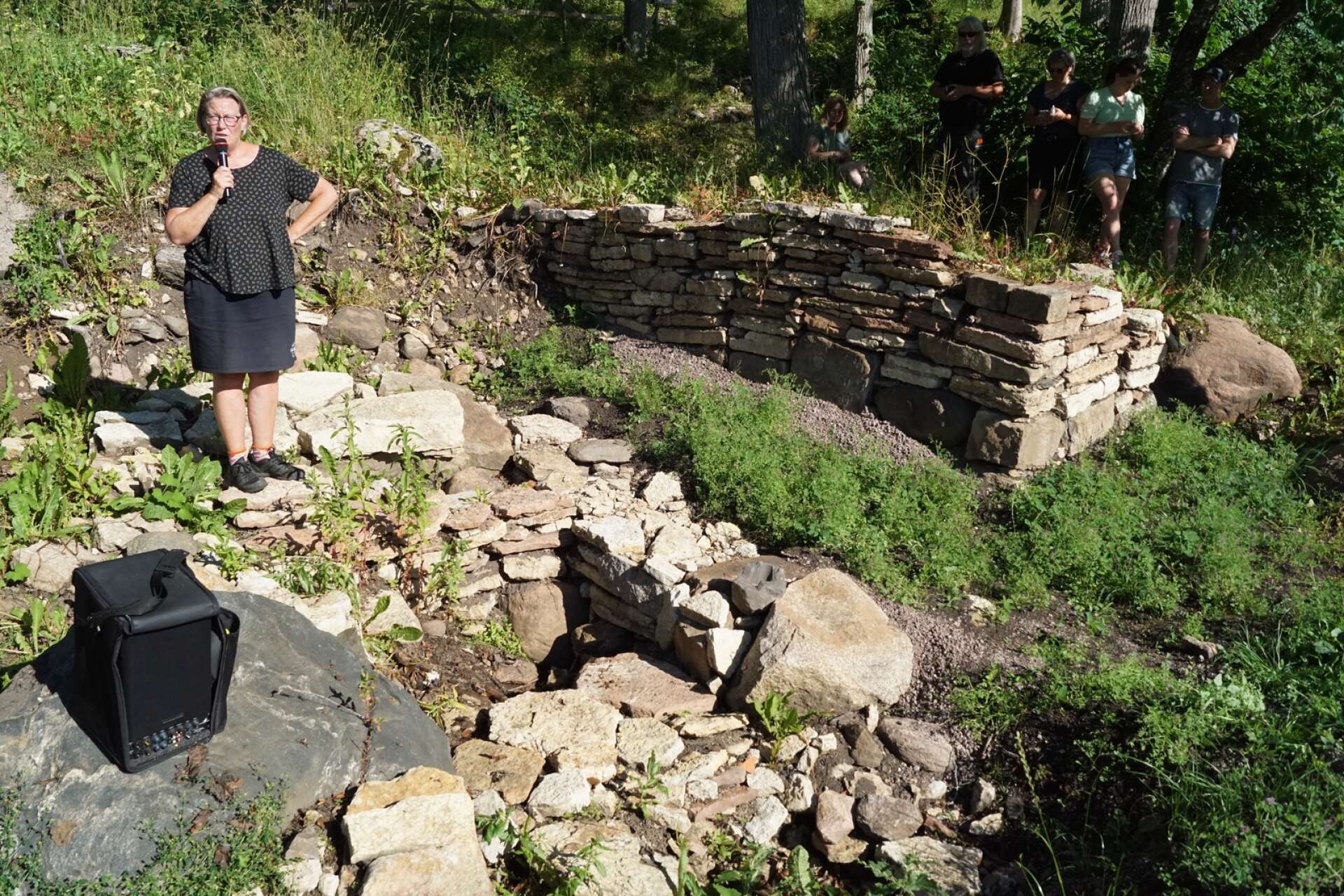 Arkeolog Maria Vretemark visar och berättar vad 2022 års vårutgrävningar hittade i Varnhem.