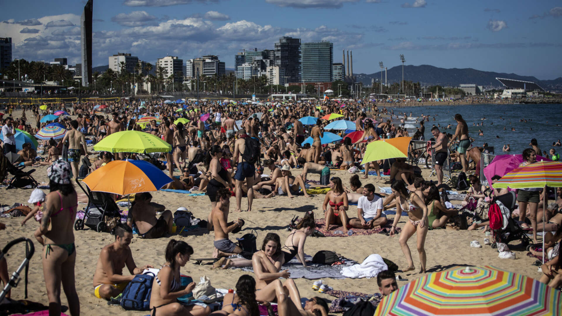 I Barcelona är stränderna redan fullpackade, men turistindustrin skriker efter fler gäster. Bild från i lördags.