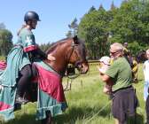Kusinbarnet Stella Hallberg hälsar på riddaren Ida Flöjsbon och hennes häst Anders. 