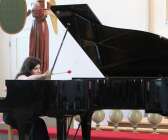 Polina Pohozha utforskade pianot i Åmåls kyrka genom att slå och spela på strängarna samtidigt som hon sjöng. 