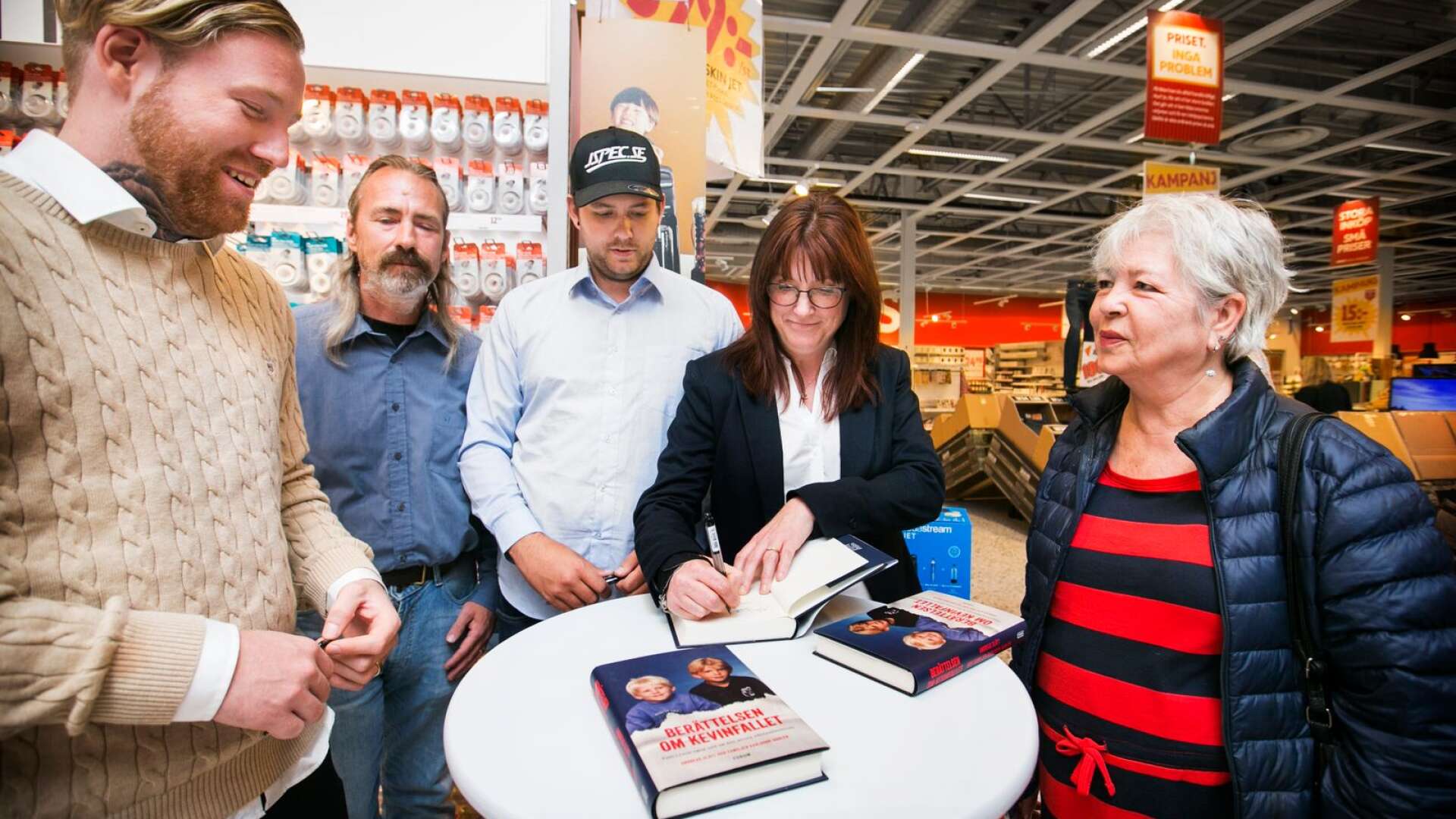 Robin Dahlén, Patrik Skog, Christian Karlsson och Annika Karlsson signerar ett ex av boken på Ica Maxi i Karlstad till Maritha Mathisen. 