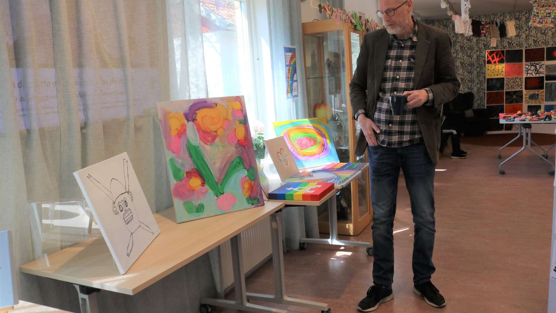 Kultursamordnare Gunnar Källström framför några av verken som skapats av daglig verksamhet i kreativt bibliotek.