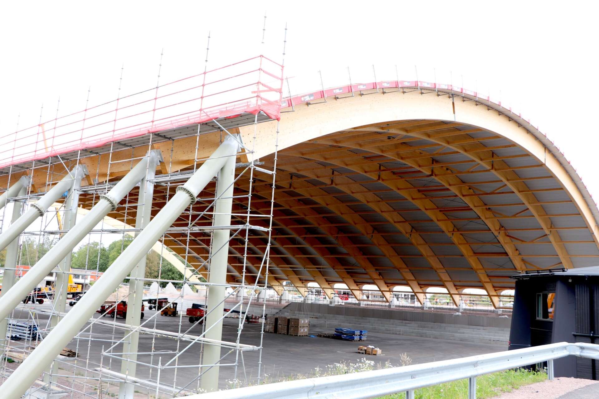 Förseningar av limträbågarna som håller taket över bandybanan har lett till ökade kostnader i byggprojektet.