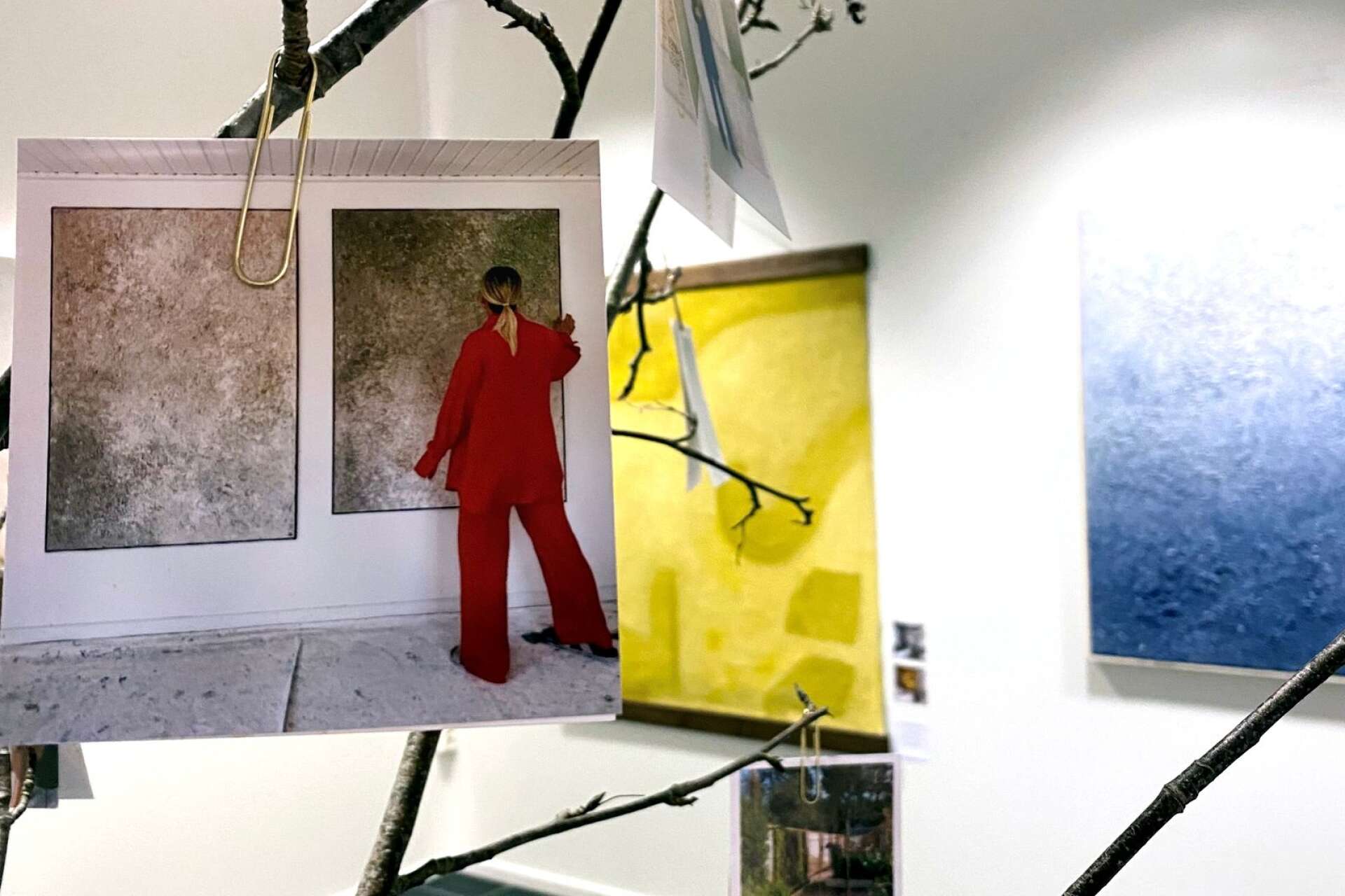 Mitt i utställningen finns ett träd, fyllt med bilder bland annat från Olivias ateljé.