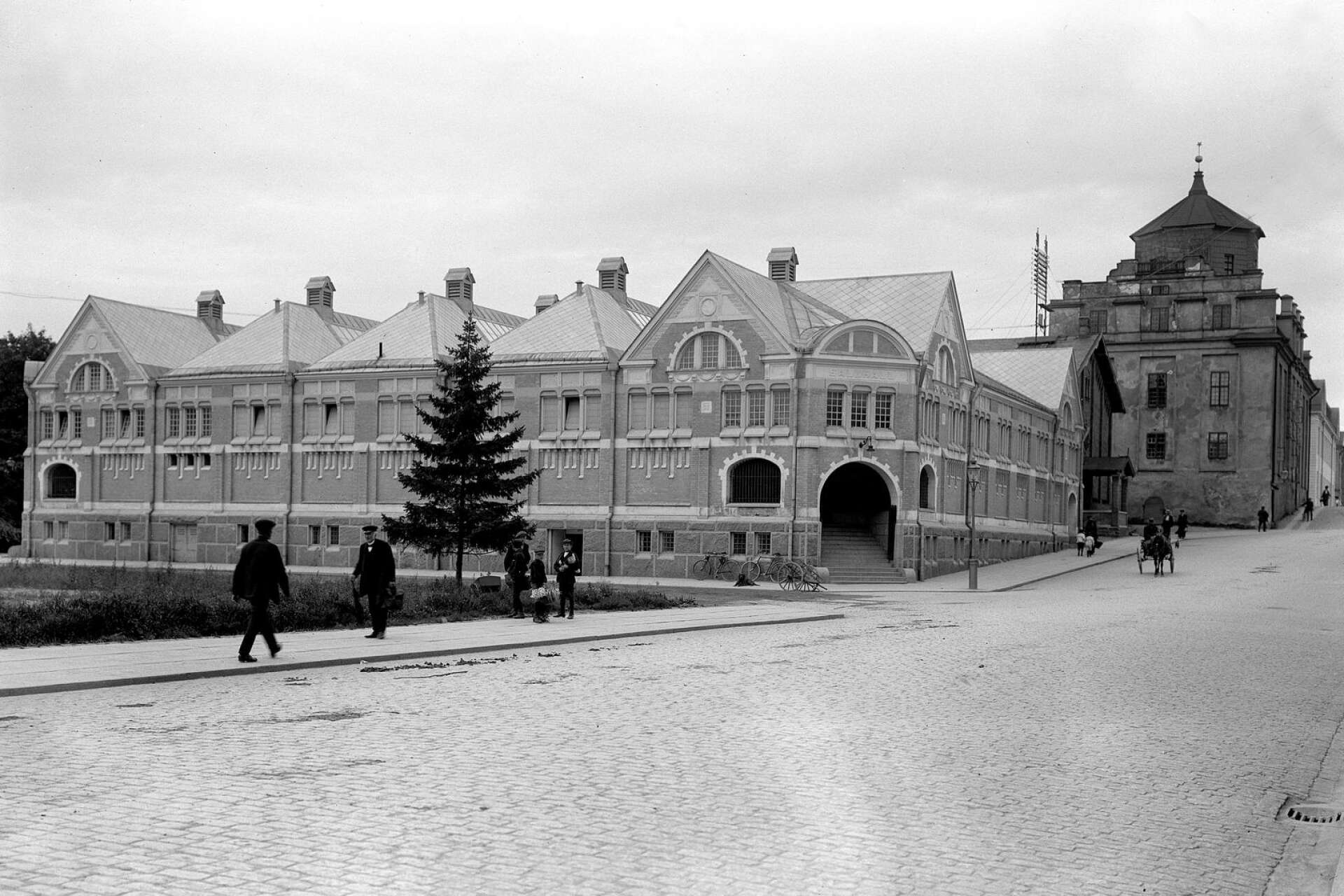 Saluhallen och Kungsgatan några år in på 1910-talet. Byggnaden ritades av stadsarkitekt Carl Crispin och invigdes den 30 oktober 1909. Bakom saluhallen syns Gamla gymnasiet.