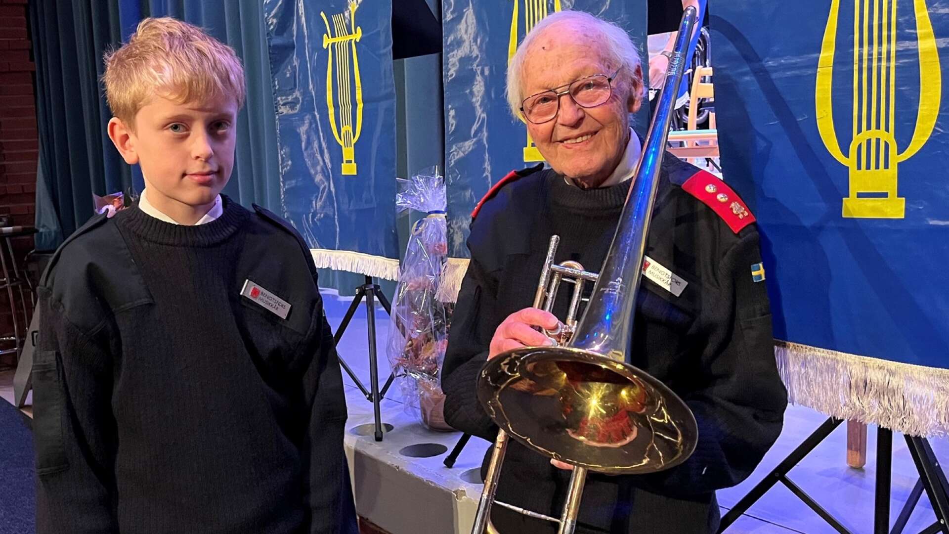 Karl-Erik Röst-Skarpnes spelar trumpet och är yngst i Bengtsfors musikkår. Här står han tillsammans med Rolf Ström, 90 år, som varit aktiv i musikkåren i 75 år. Han spelar bland annat tuba och basun.
