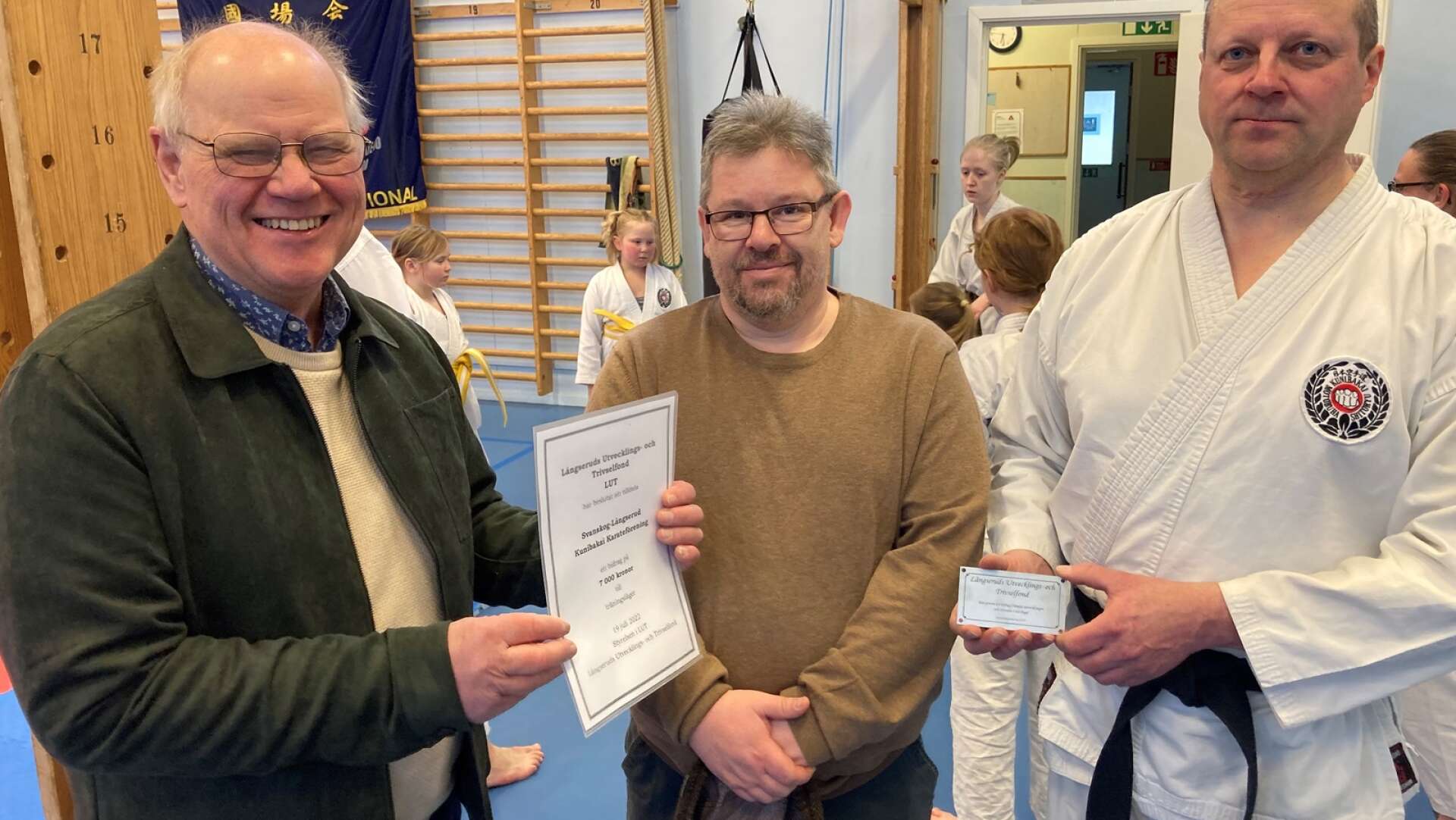 Anders Axelsson, ordförande för LUT-fonden i Långserud överlämnar 7000 kr som bidrag till Kumibakais karateförening.