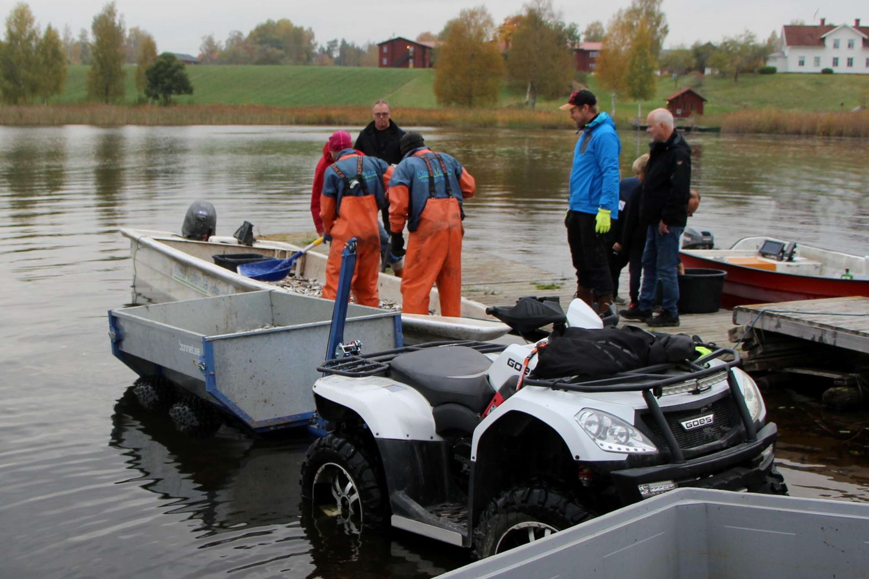 Johan Hammarlund i blå jacka, har backat fyrhjulingen till Sirsjön för att lasta all fisk, som gavs bort till de som ville ha.