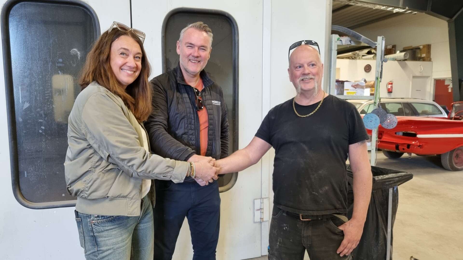 Eva-Klara Blomberg Högväg  och Jonas Pettersson från Husbilslandet förseglar affären genom ett handslag med Hazze Eriksson på Autolacken.