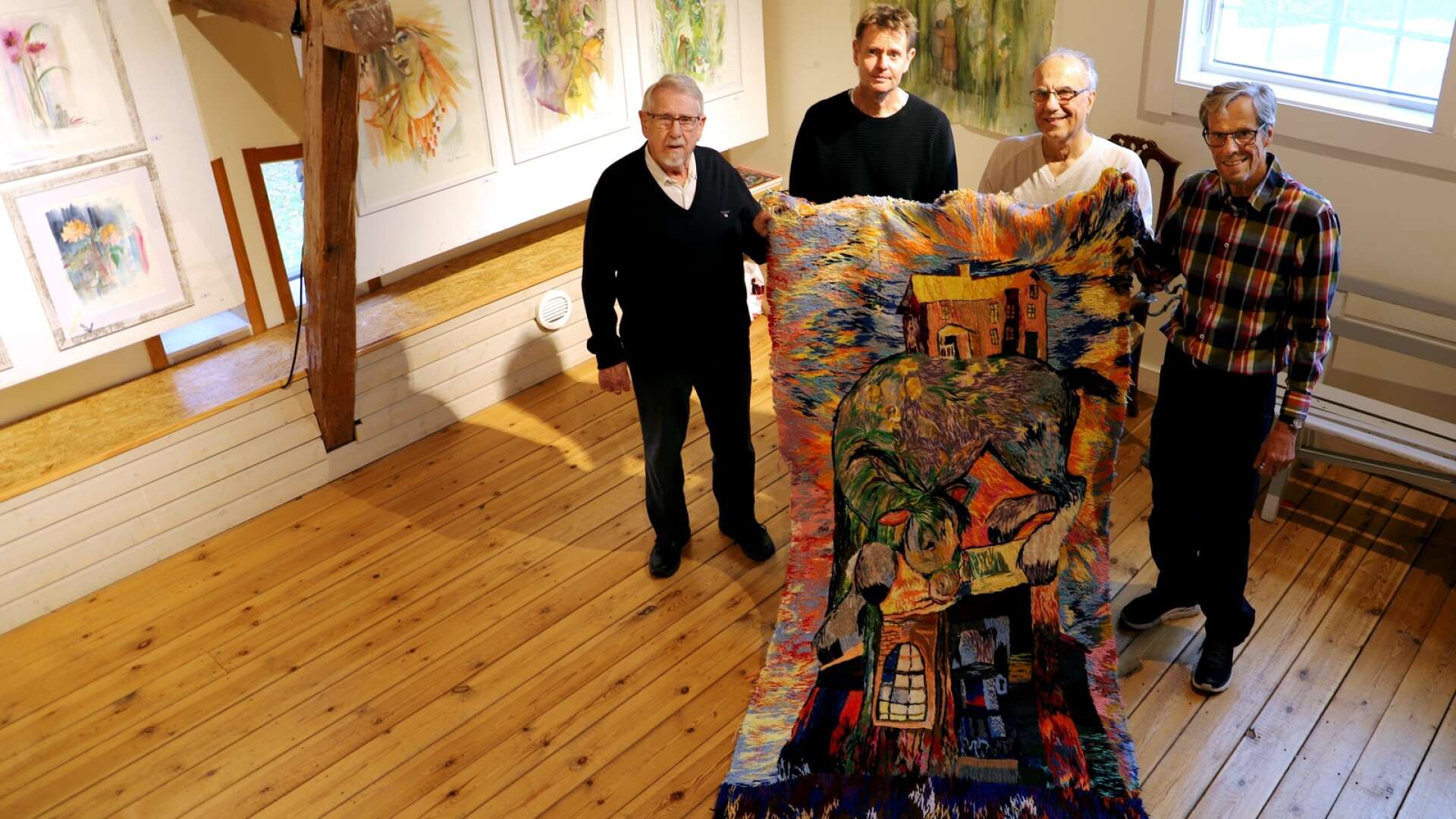 Per-Erik Hedell, Peter Jansson, Ali Samimi och Bo Wiktorsson visar gästutställaren Marja i Myroms maffiga textilverk.