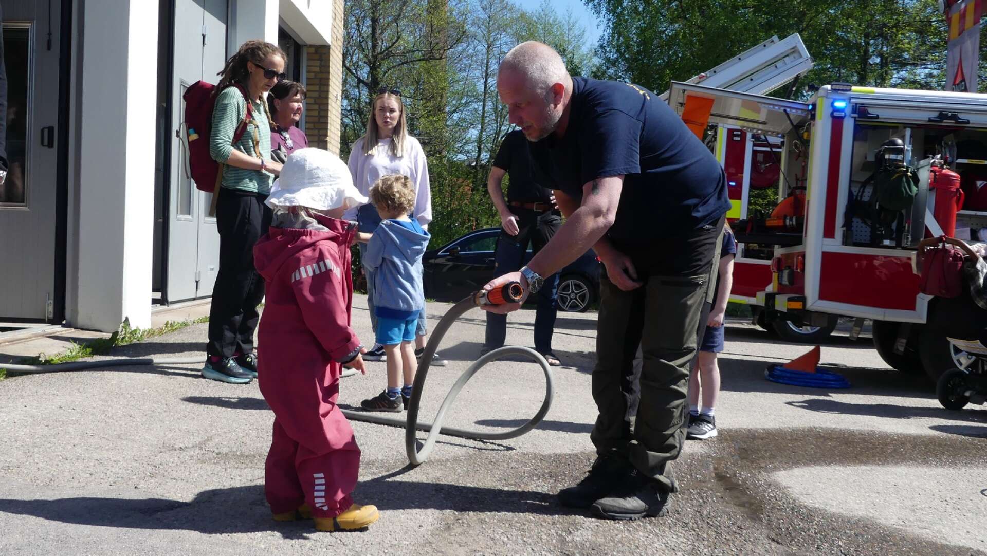 Lilla Elisabeth Claesson fick testa att spruta med brandslangen, assisterad av brandmannen Jocke Lindqvist.