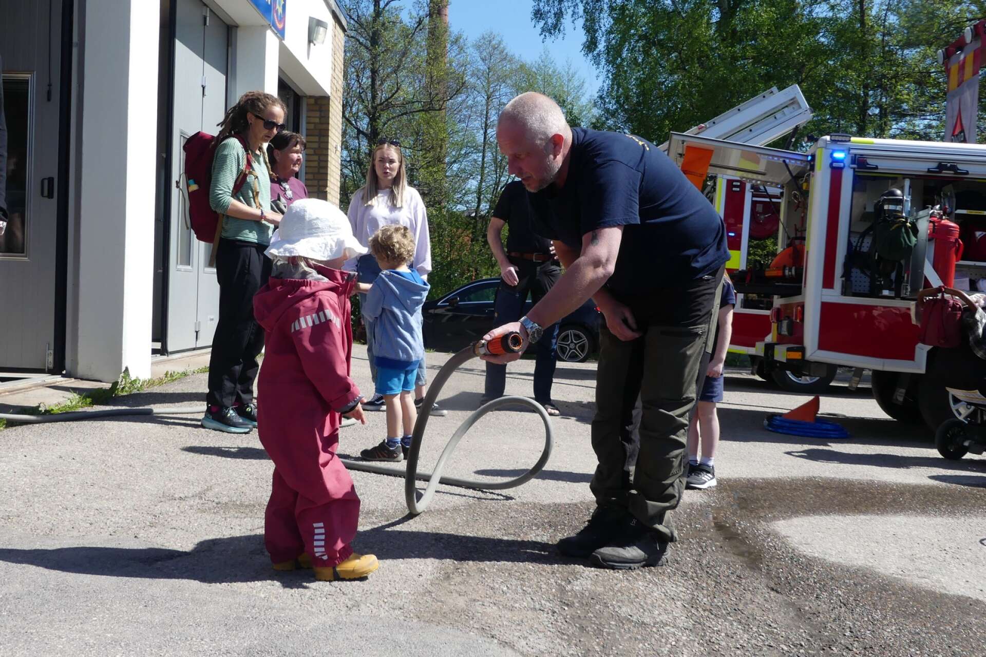 Lilla Elisabeth Claesson fick testa att spruta med brandslangen, assisterad av brandmannen Jocke Lindqvist.