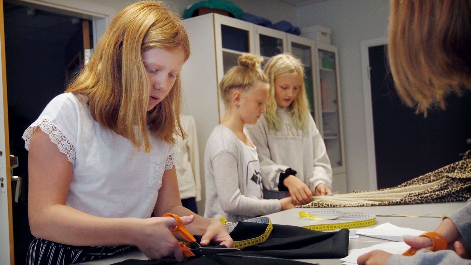 Eleverna Astrid Andersson, Clara Glad och Felicia Lindh gör en egen tygkasse.